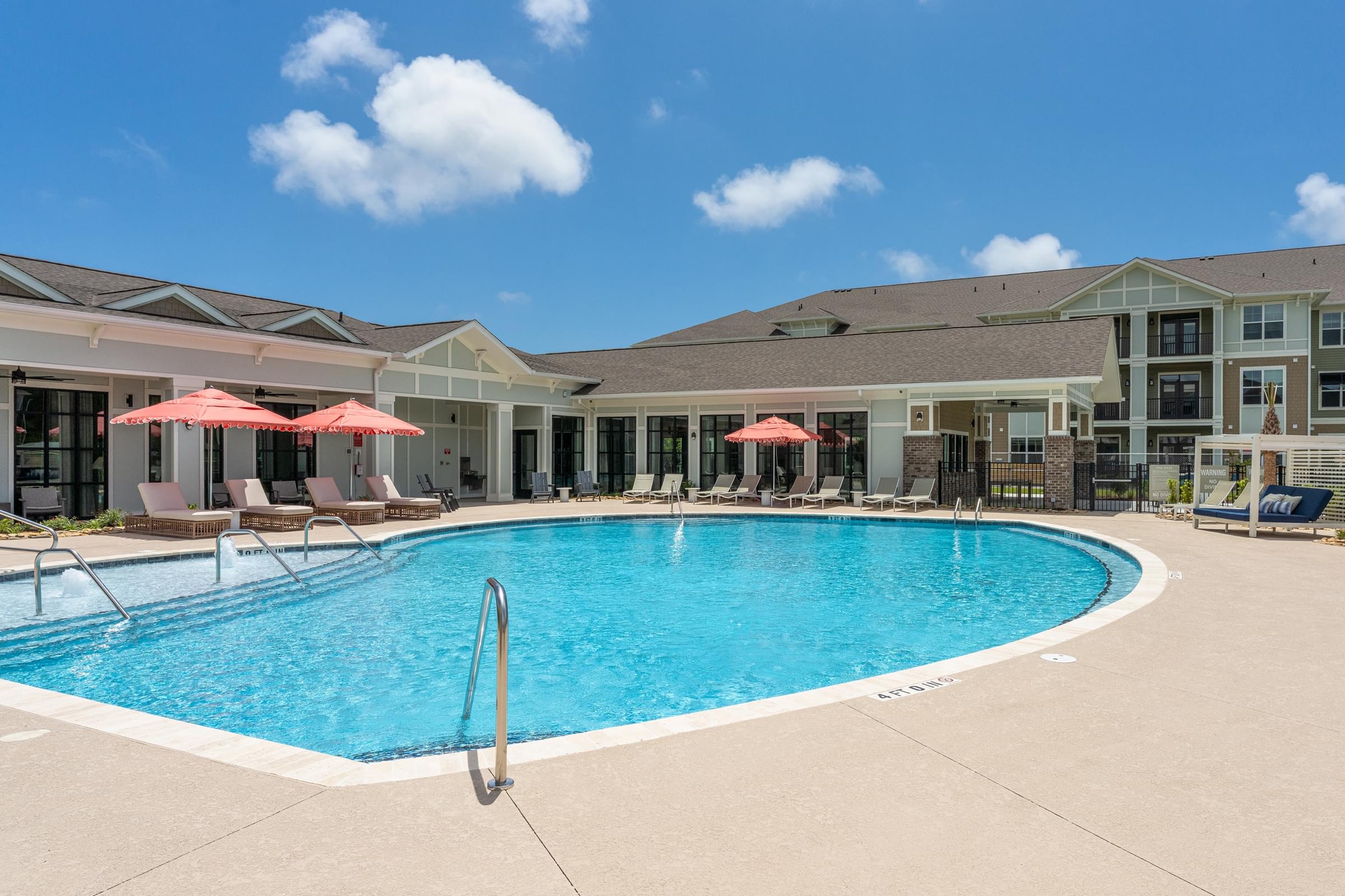 A large swimming pool with a diving board in the middle of it.
