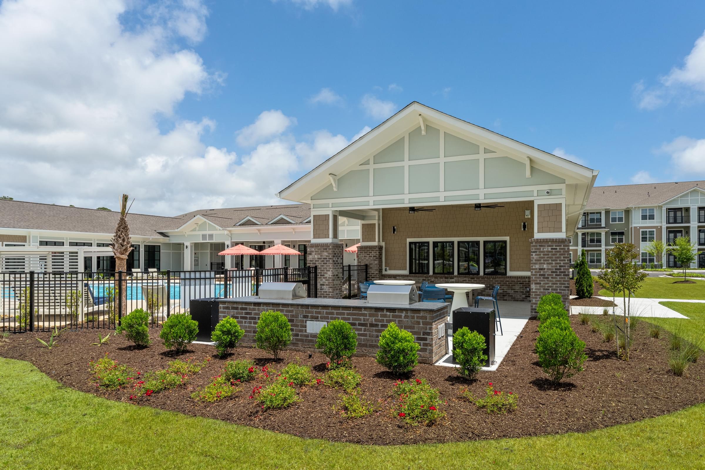 A house with a pool and a landscaped garden in front.
