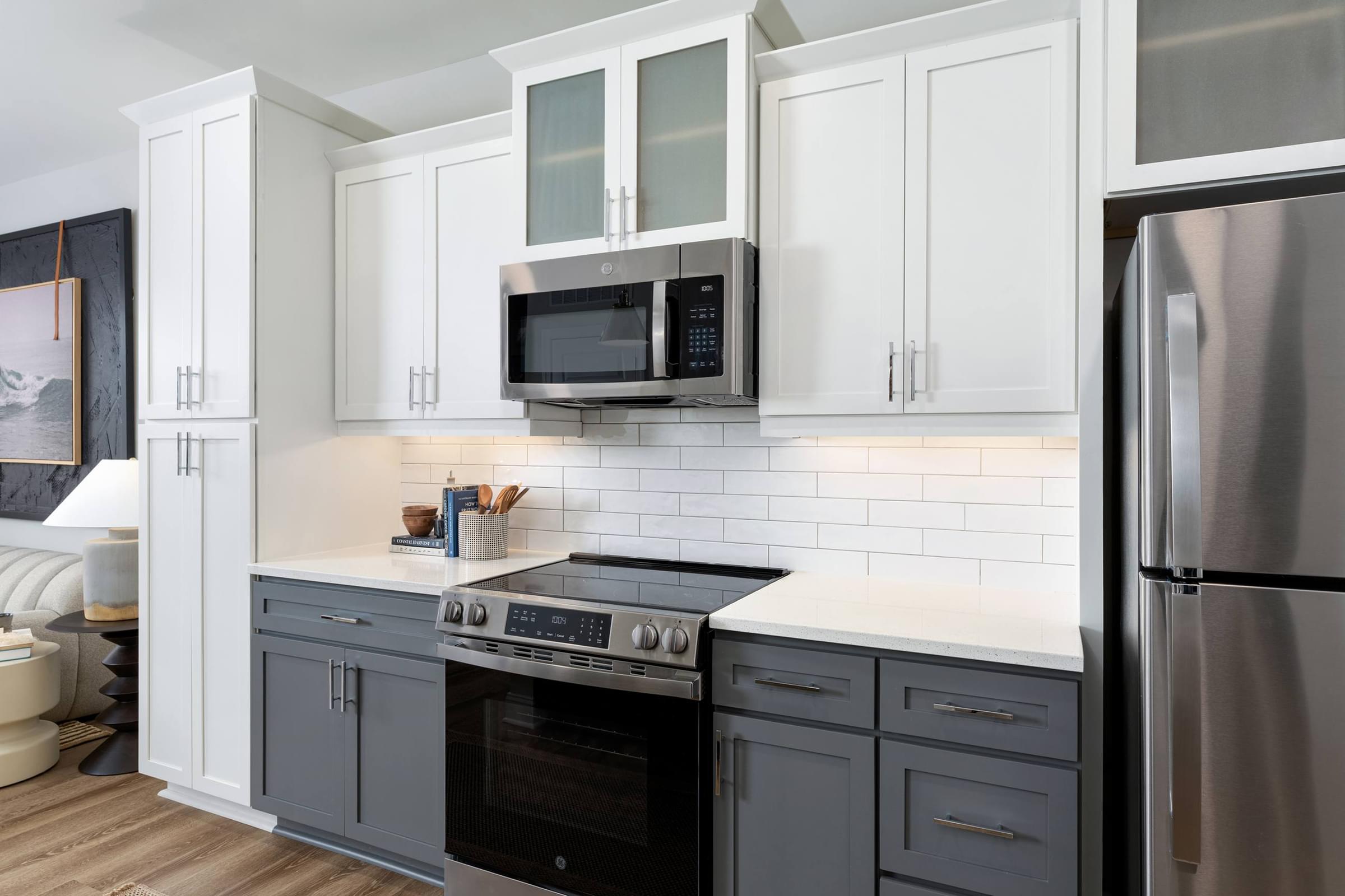 A modern kitchen with a stainless steel refrigerator and a black oven.