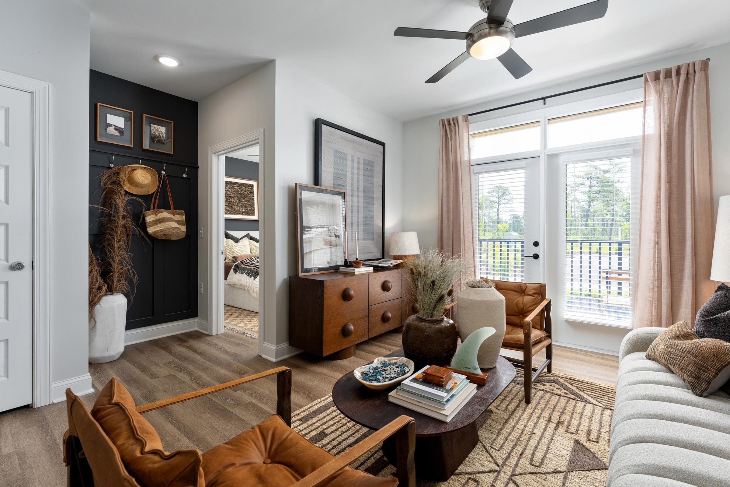 A living room with a brown chair and a brown dresser.
