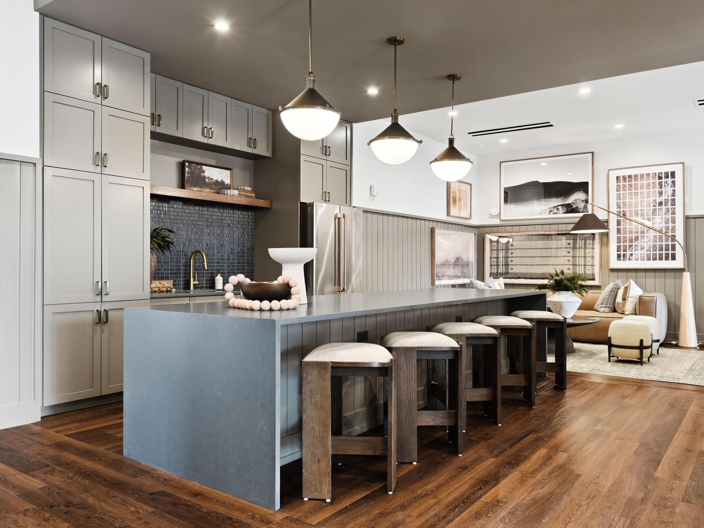 A modern kitchen with a grey island and white cabinets.