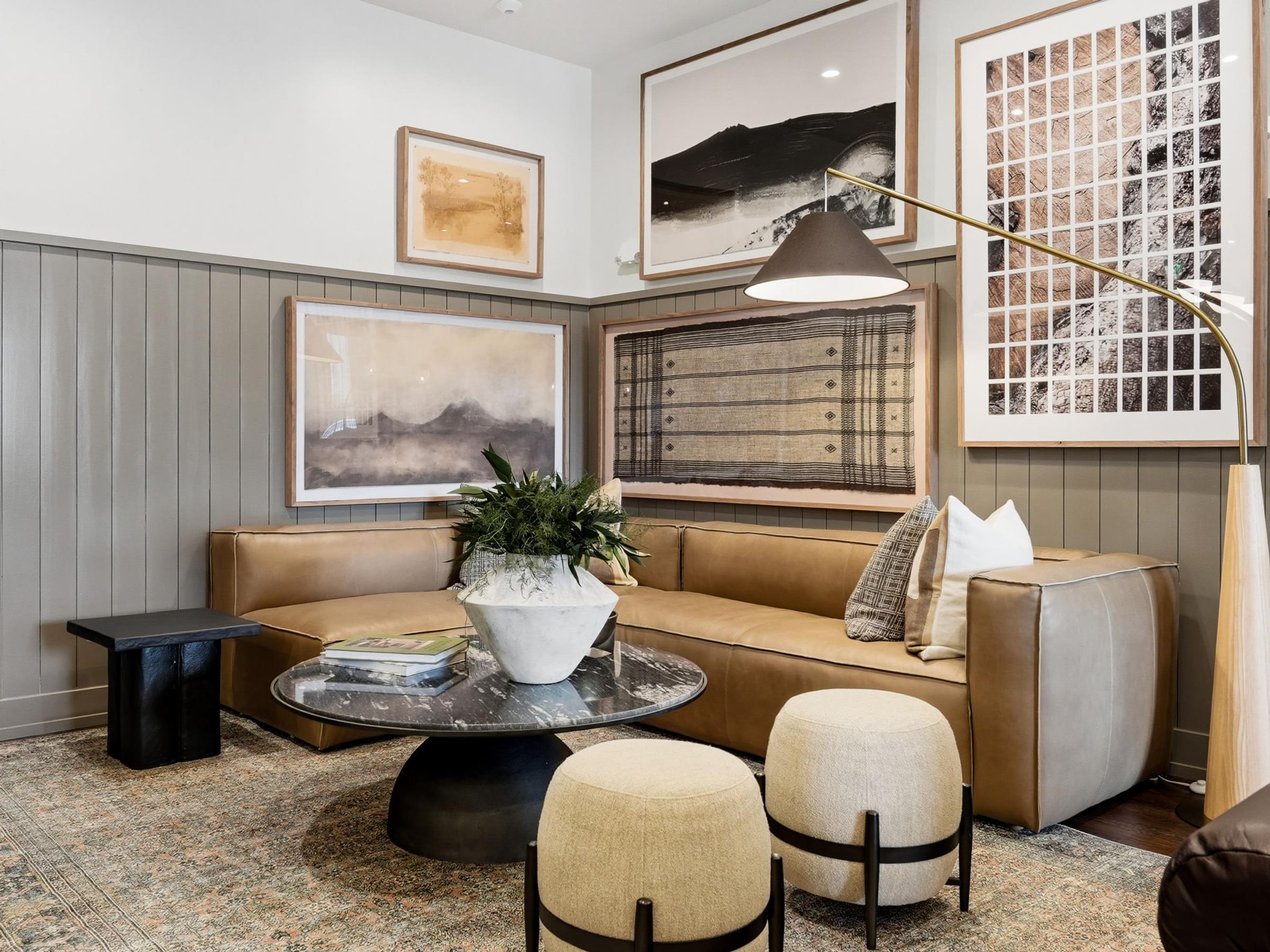 A living room with a brown couch, a coffee table, and a potted plant.