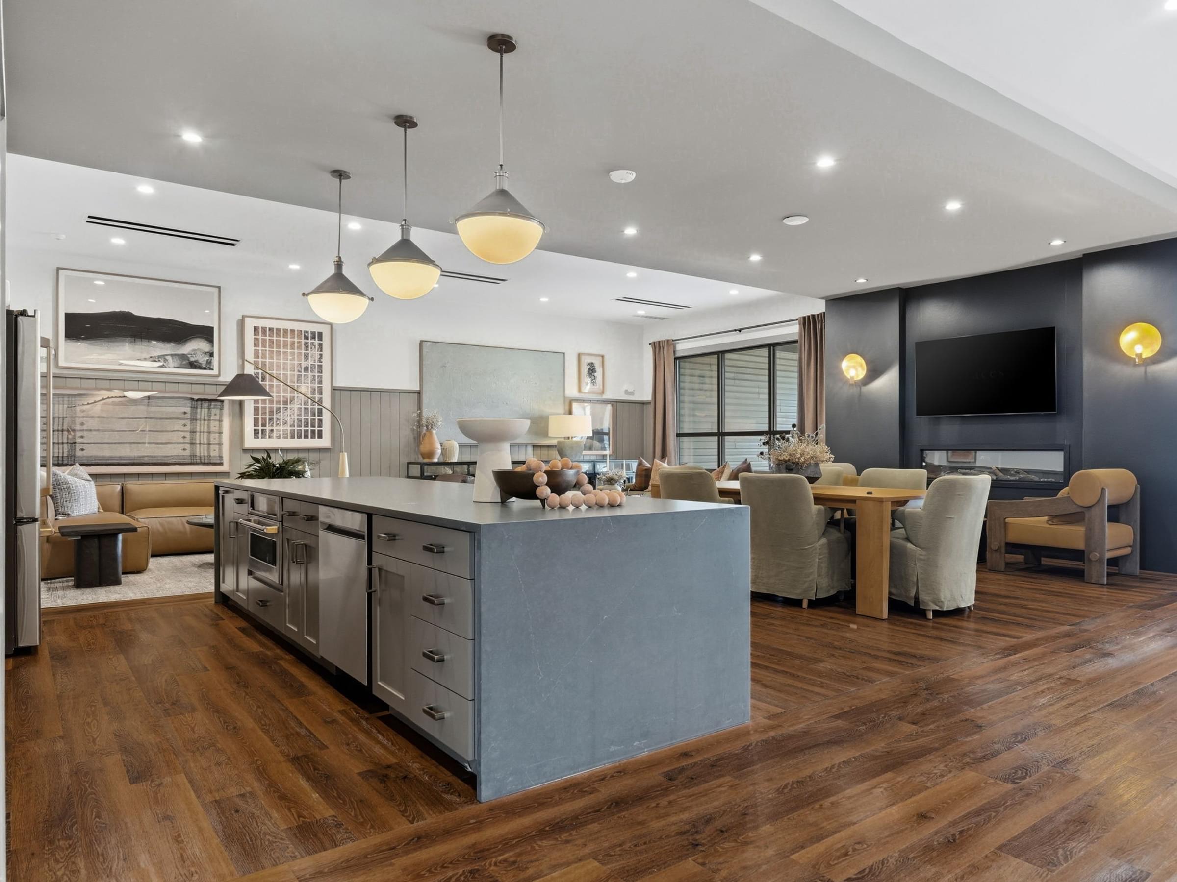 A modern kitchen with wooden floors and a large island.