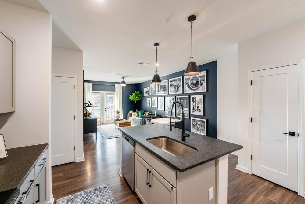 an open kitchen and living room with a sink and a counter top