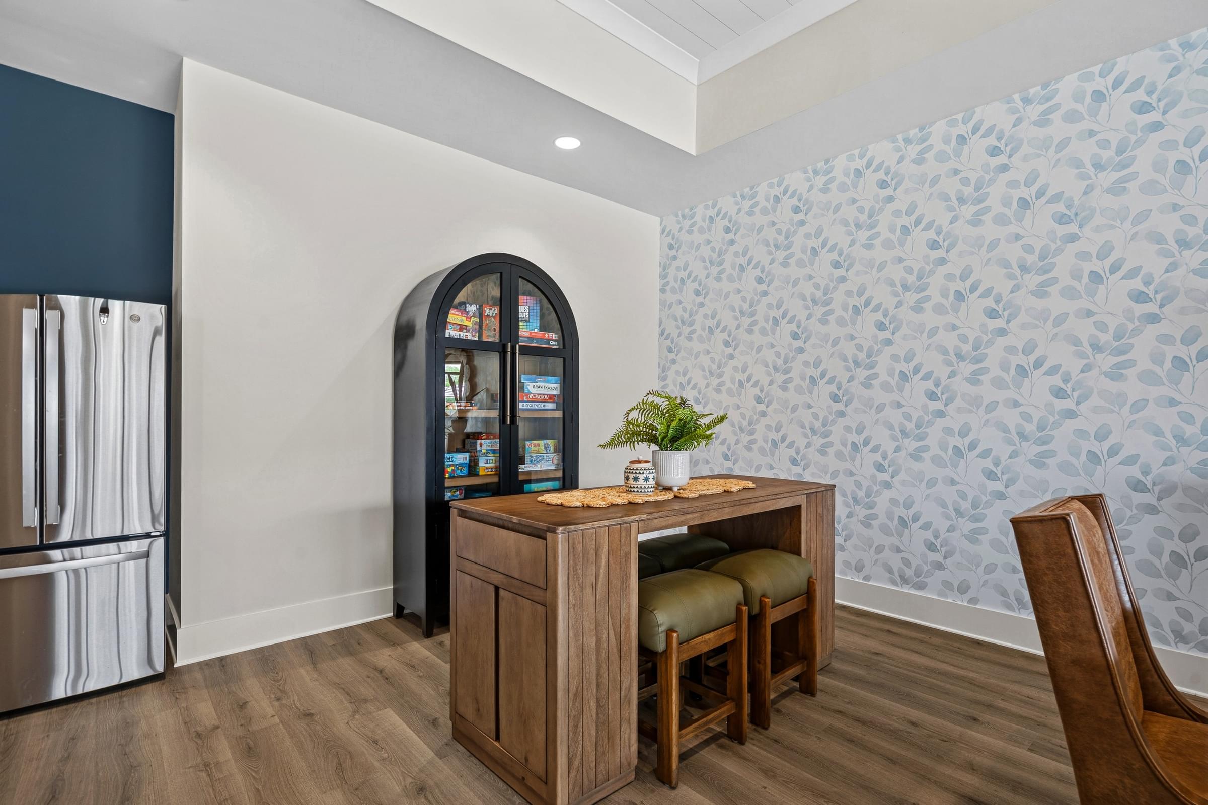 A kitchen with a wooden table and chairs and a fridge.
