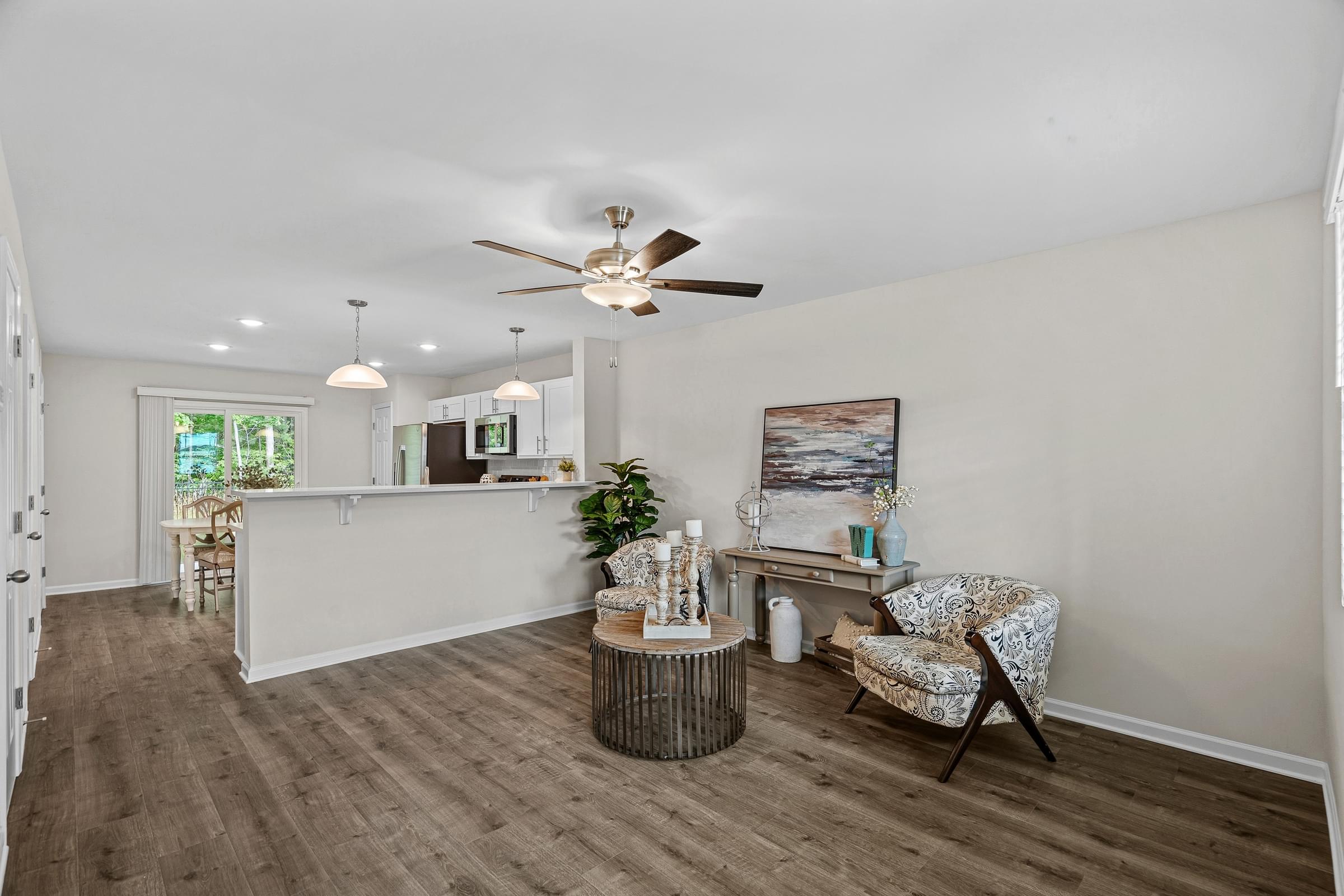 A room with a ceiling fan and a chair.