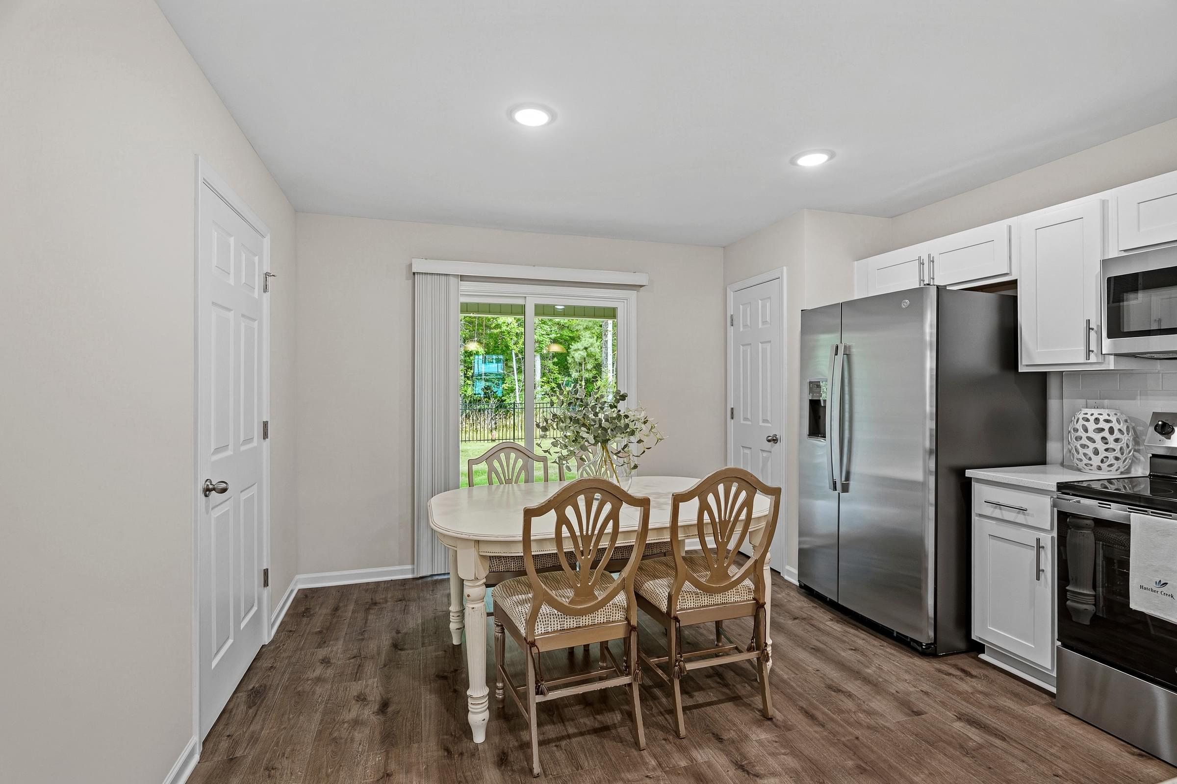 A kitchen with a table and chairs in front of a window.