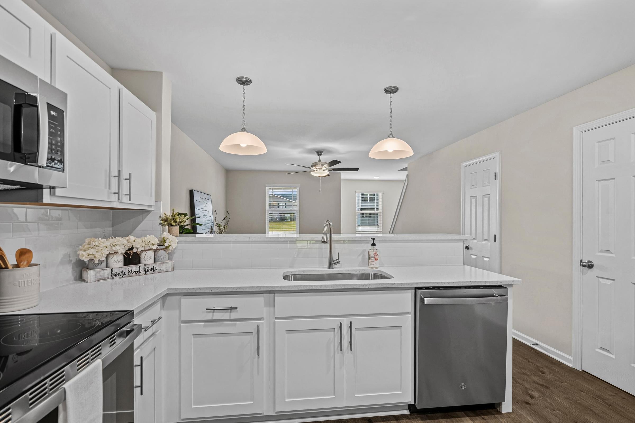 A kitchen with white cabinets and a black stove top.