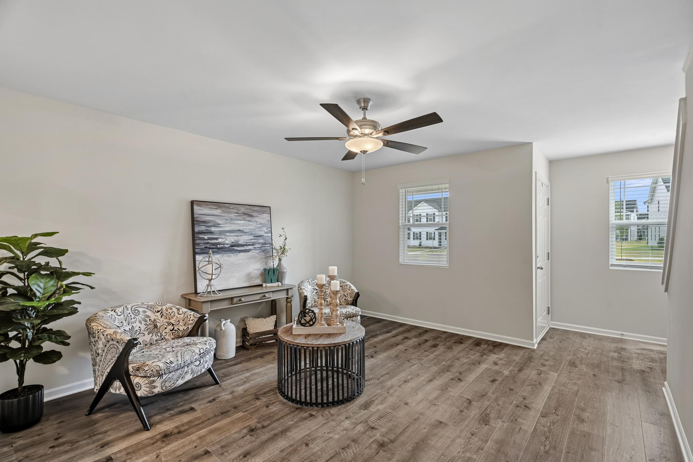 A room with a ceiling fan and a chair.