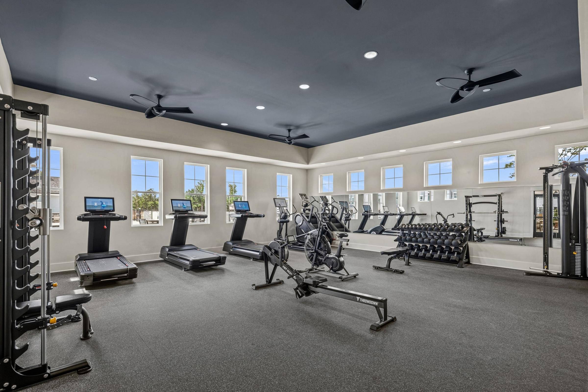 A spacious gym with treadmills, elliptical machines, and other exercise equipment.