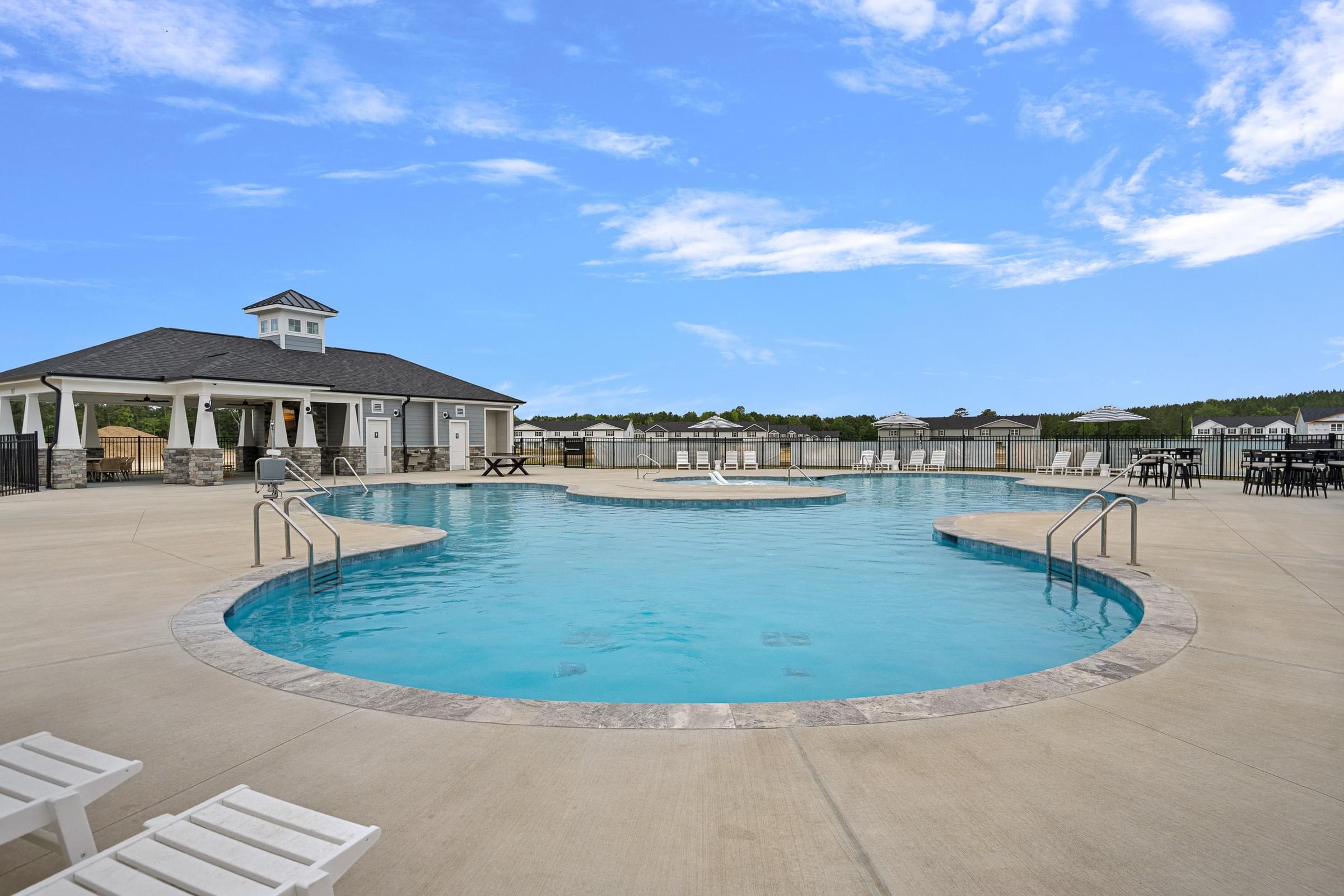 A large outdoor swimming pool with a gazebo-like structure next to it.