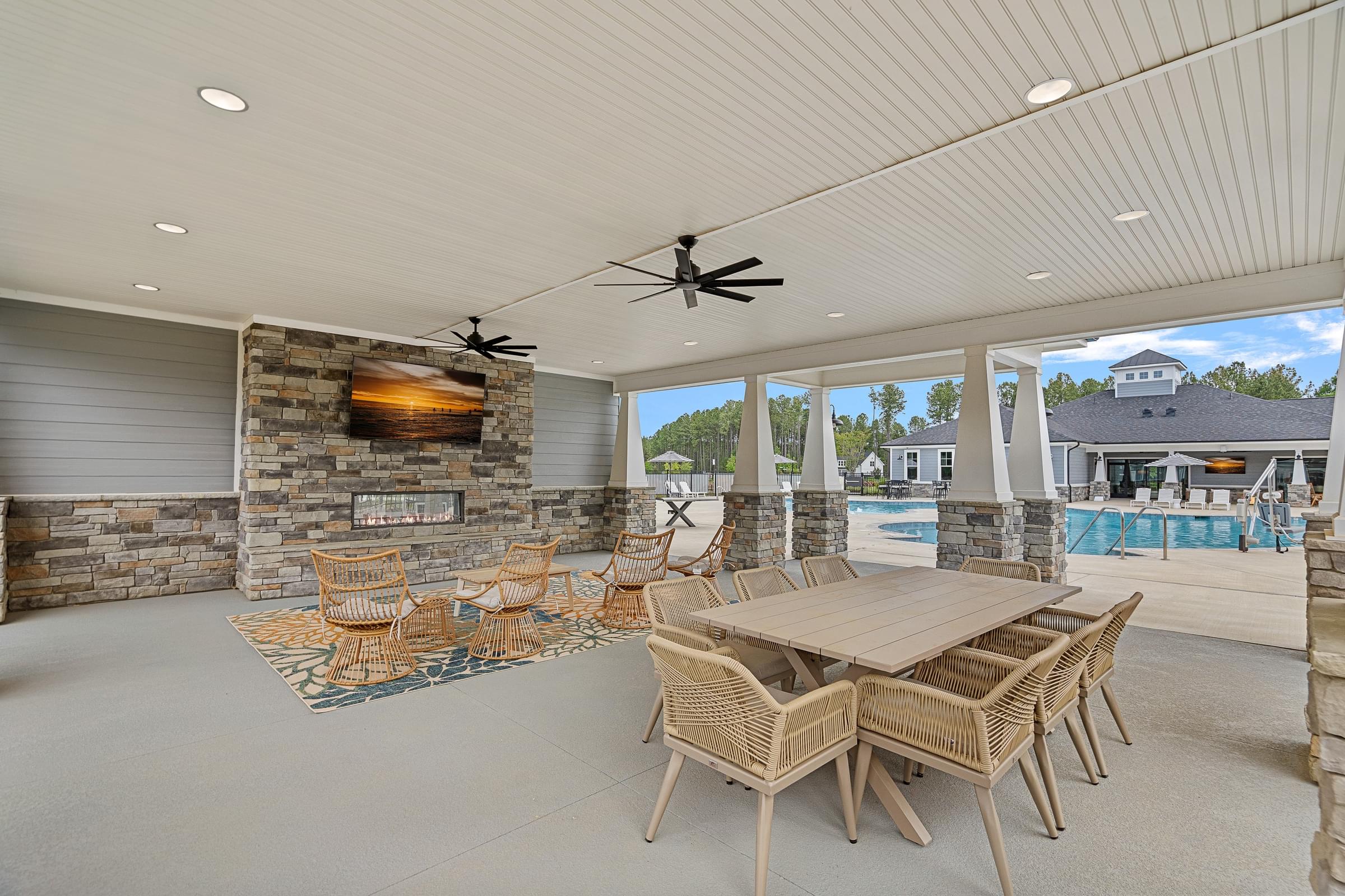 A patio with a table and chairs and a ceiling fan.