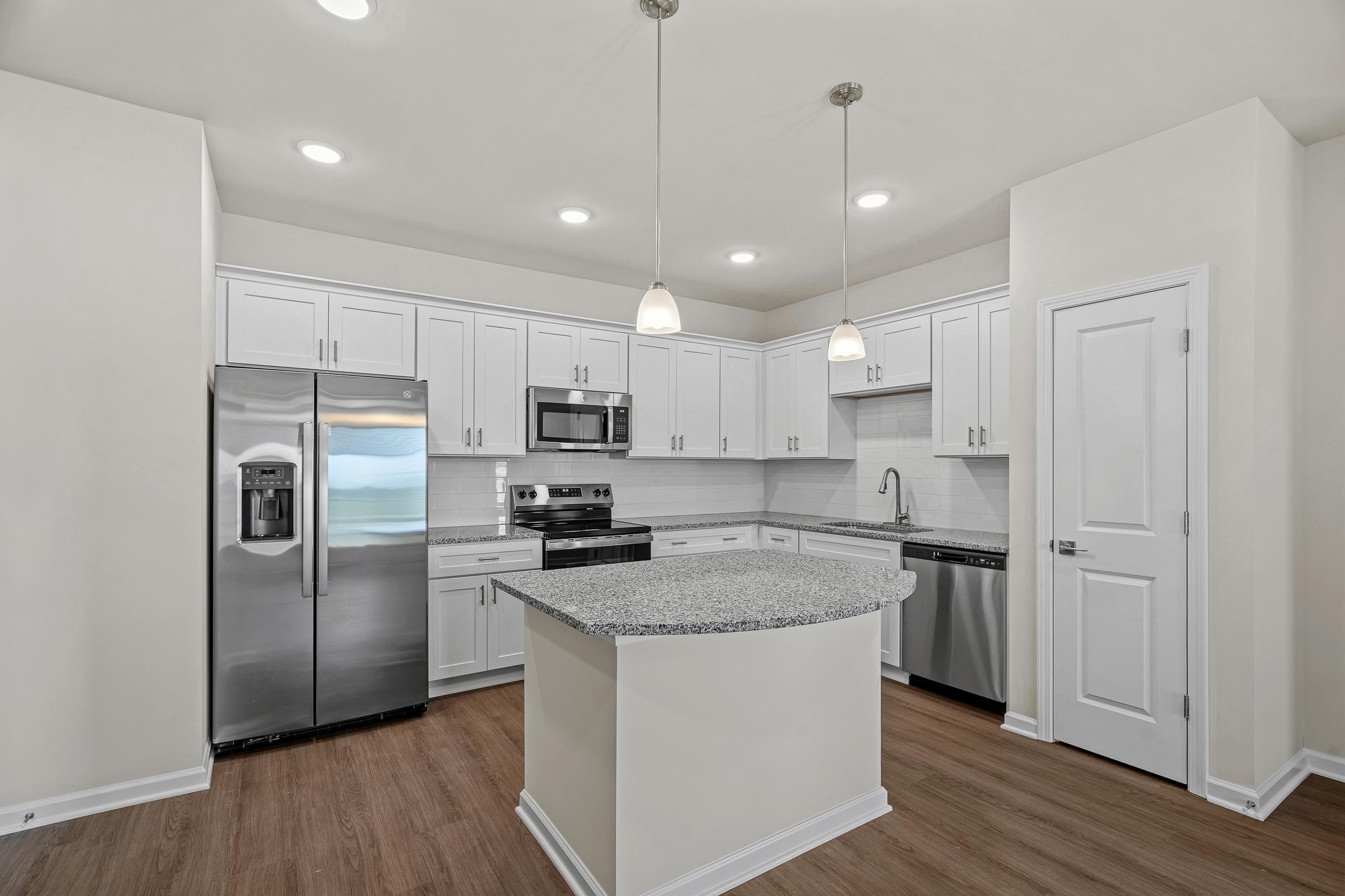 A modern kitchen with stainless steel appliances and a central island.