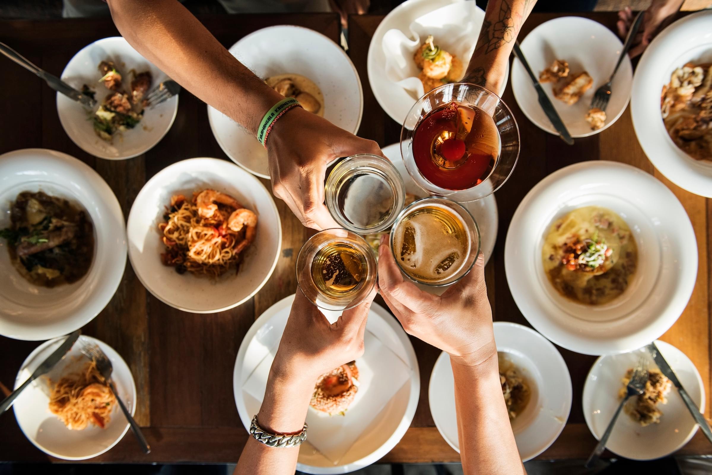 A group of people toasting with drinks at a dinner table.