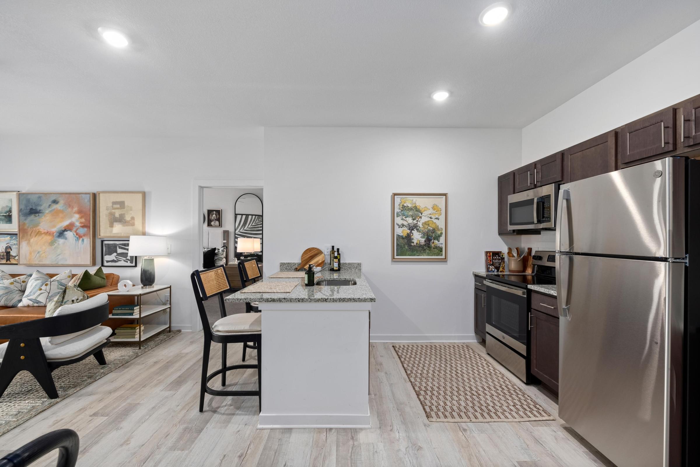A modern kitchen with a white island and stainless steel appliances.