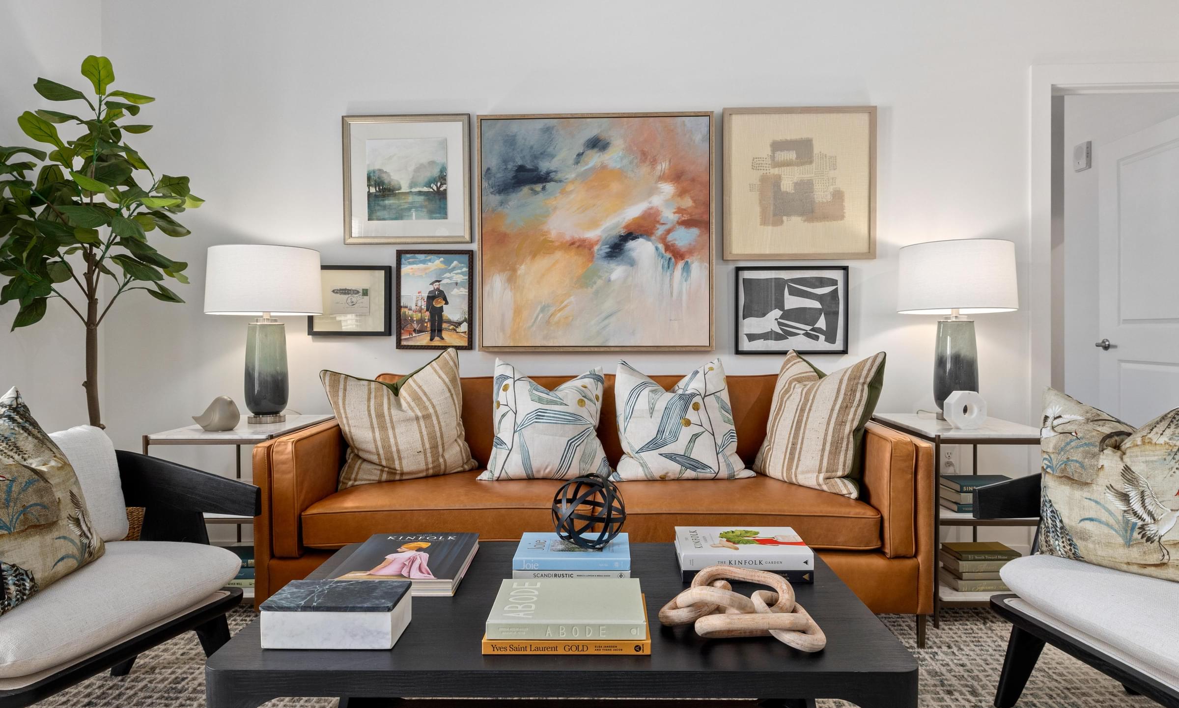 A living room with a brown couch, a black coffee table, and a potted plant.