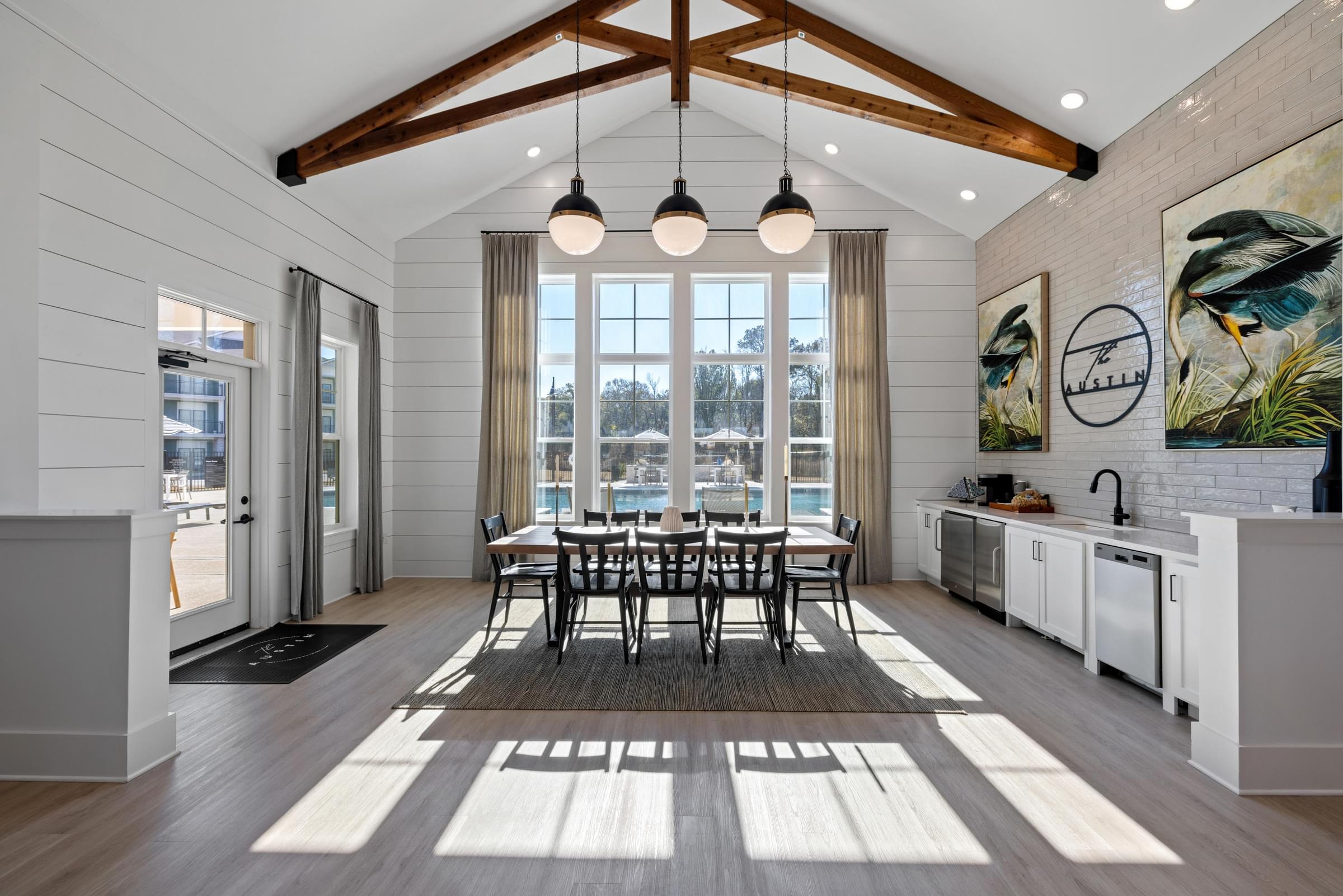 A modern kitchen with a dining table and chairs in the middle of the room.