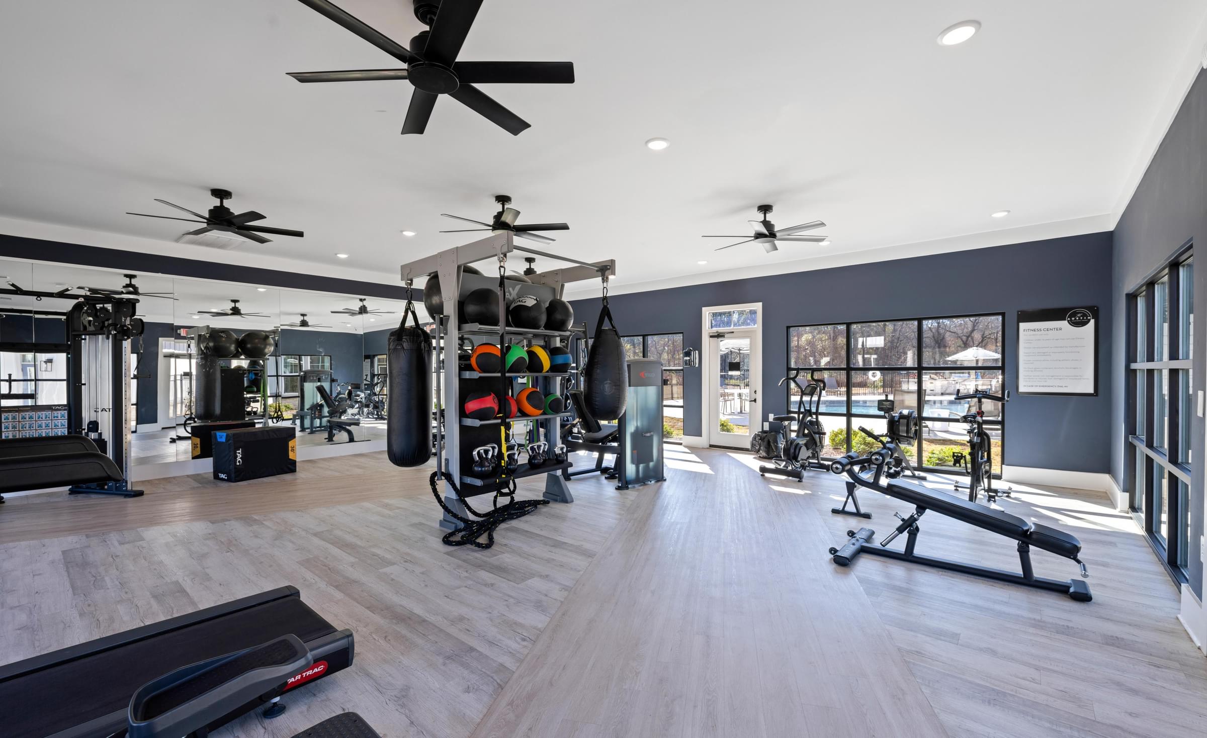 A gym with a variety of equipment including treadmills, weights, and exercise machines.