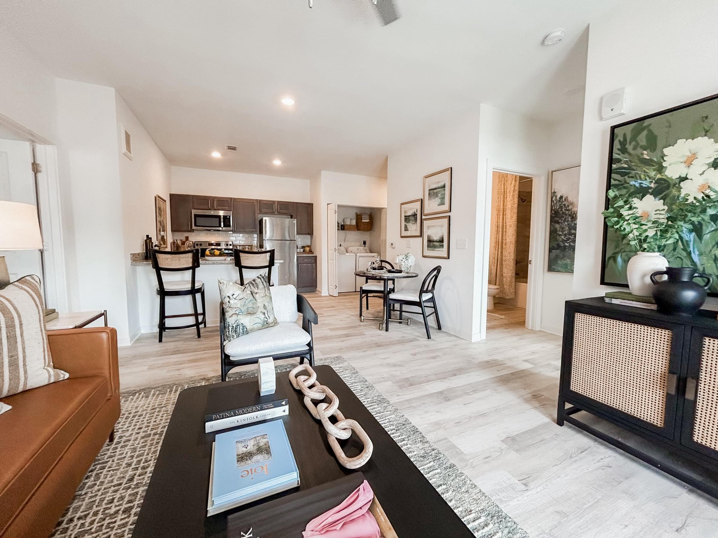A living room with a couch, coffee table, and a painting on the wall at The Austin apartments in Opelika, AL.