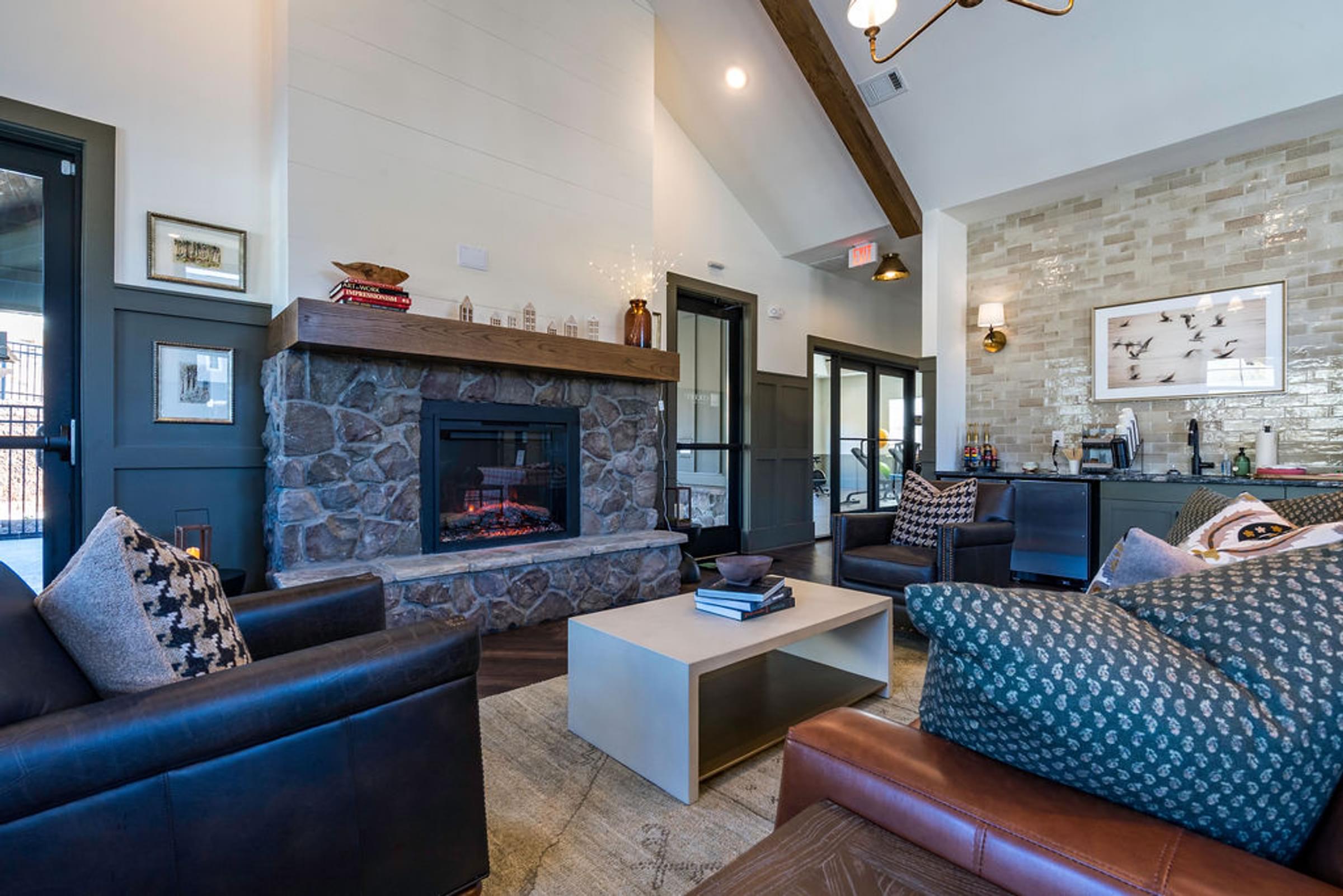 A living room with a stone fireplace and a couch.