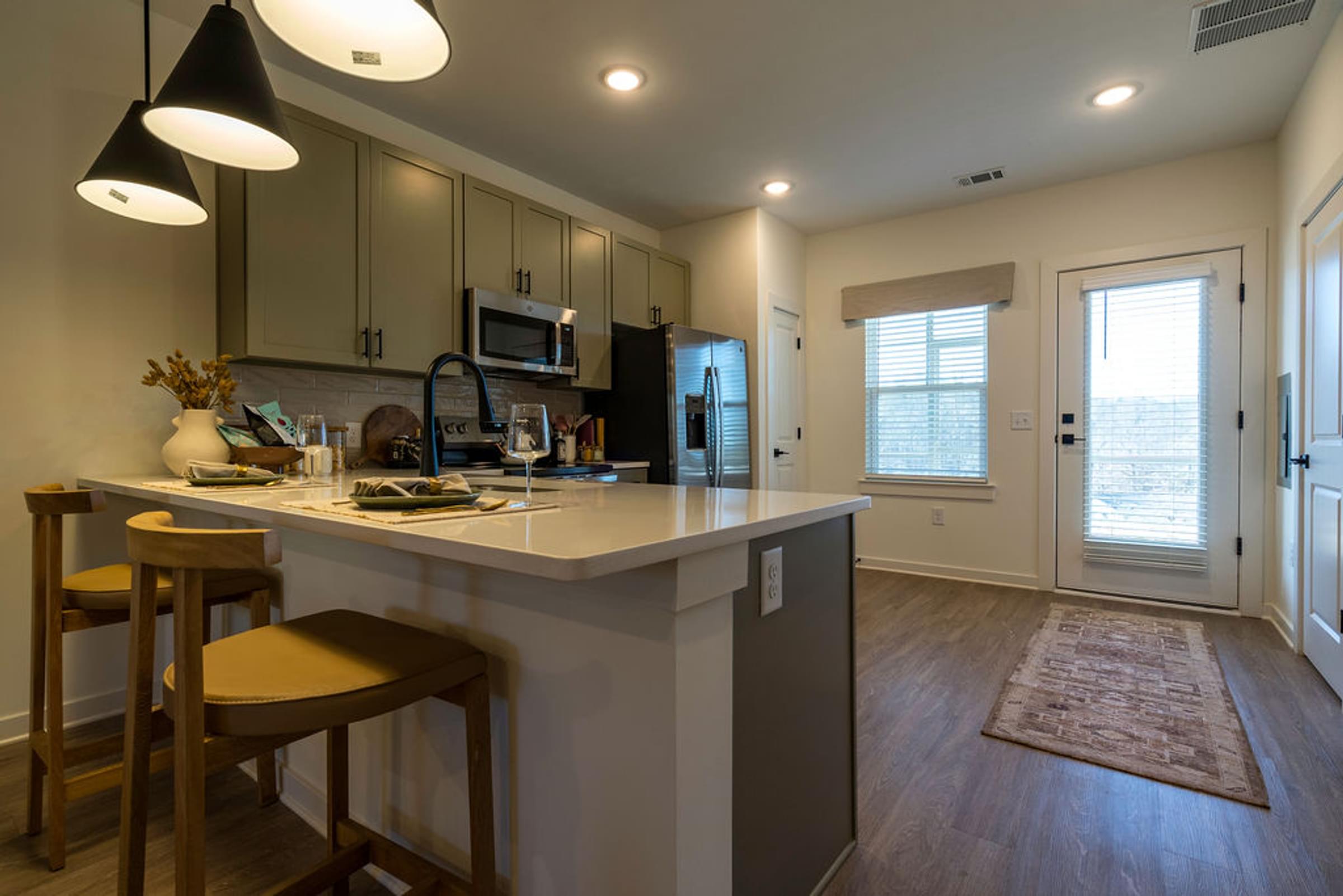 A kitchen with a bar area and a refrigerator.