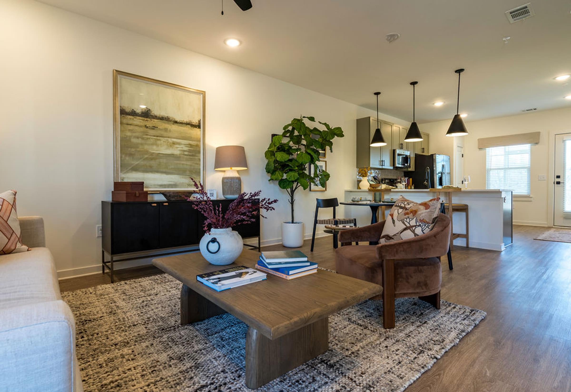 A living room with a brown sofa, a coffee table, and a painting on the wall.