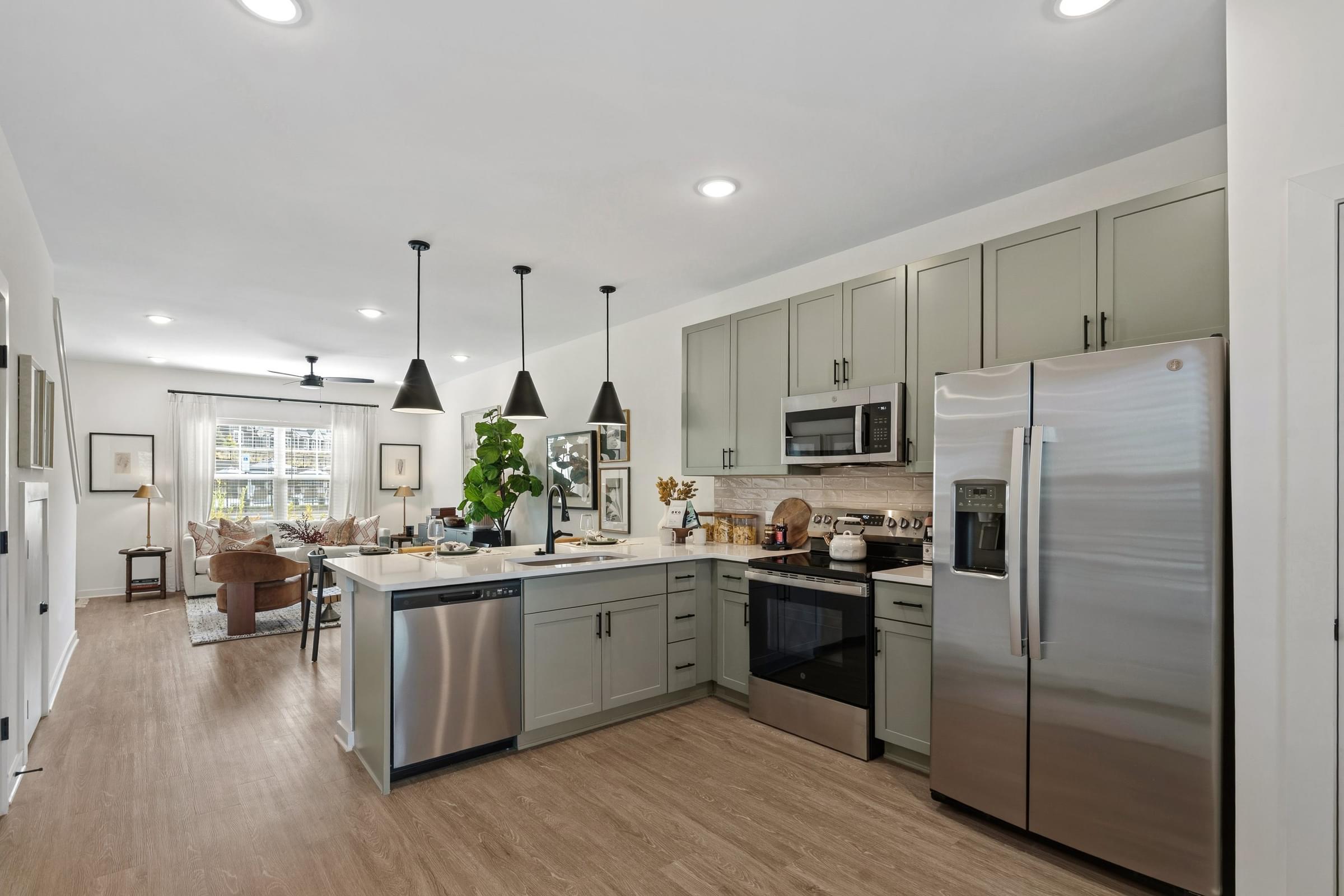 A modern kitchen with stainless steel appliances and wooden flooring.