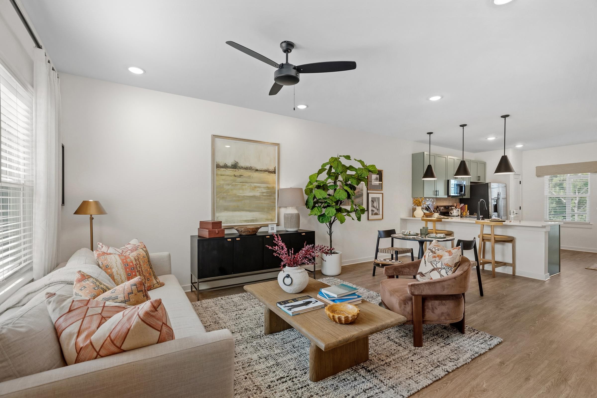 A living room with a couch, a coffee table, and a ceiling fan.