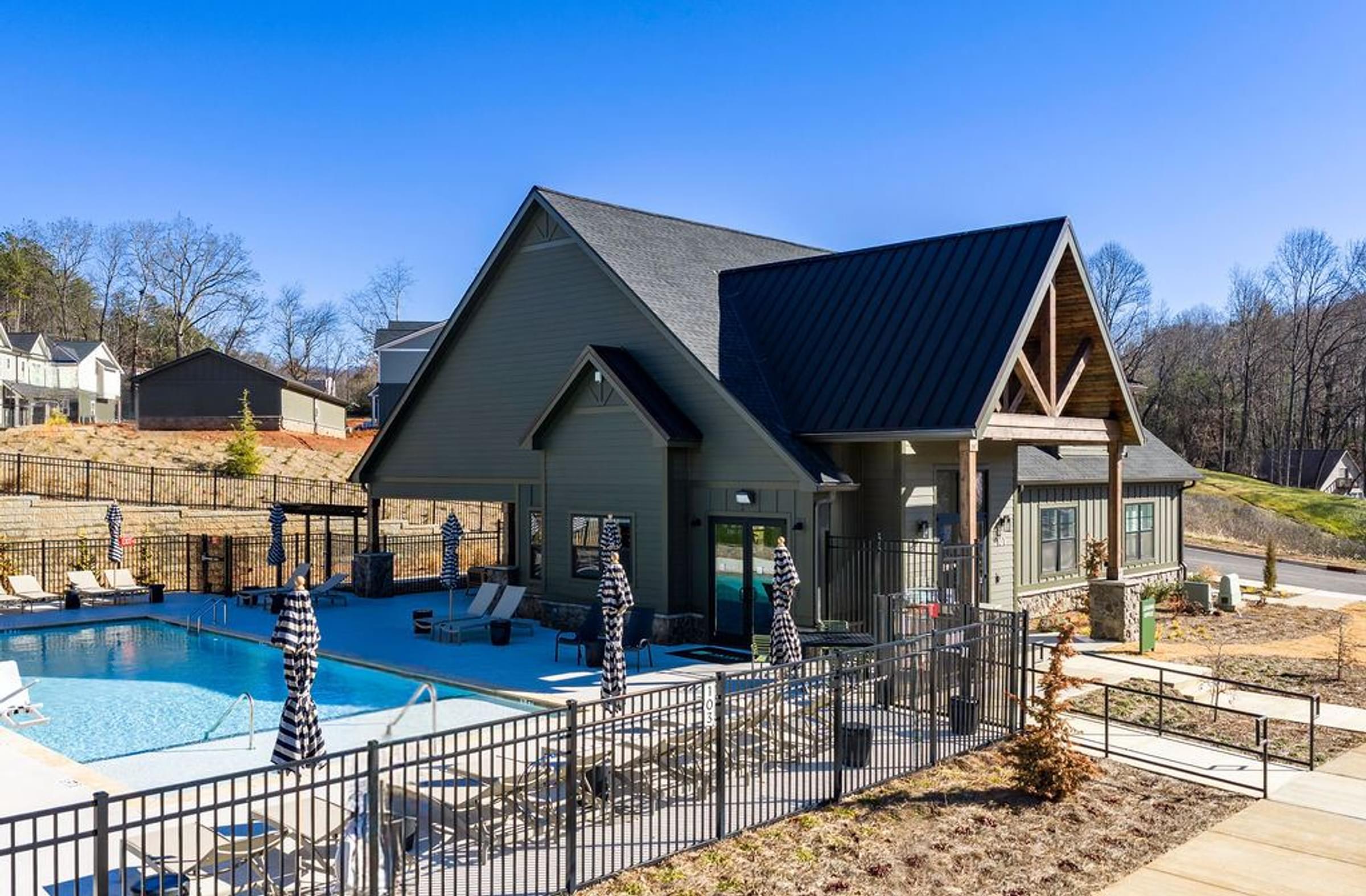 A house with a pool in front of it.