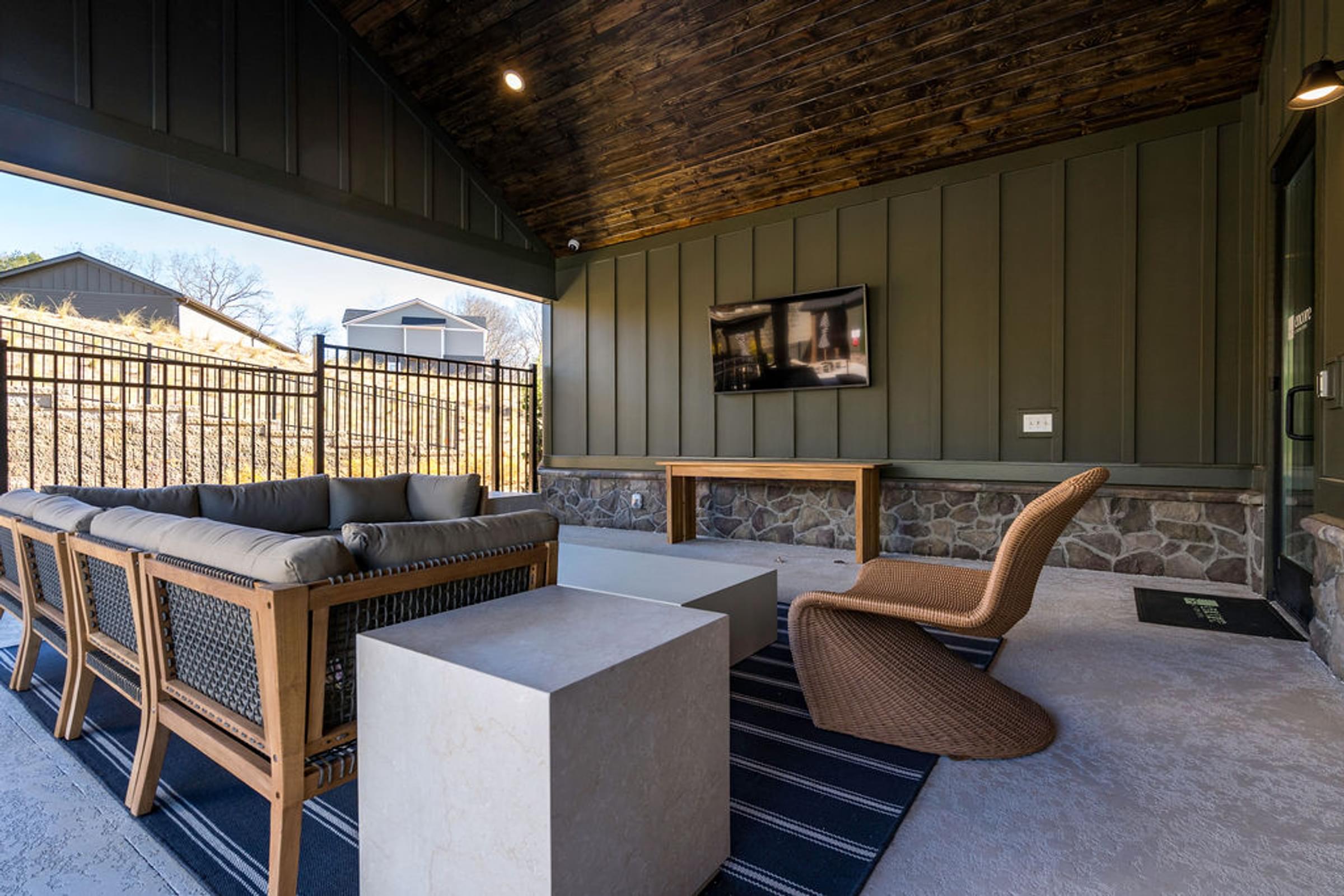 A room with a wooden ceiling and a green wall with a TV on it.