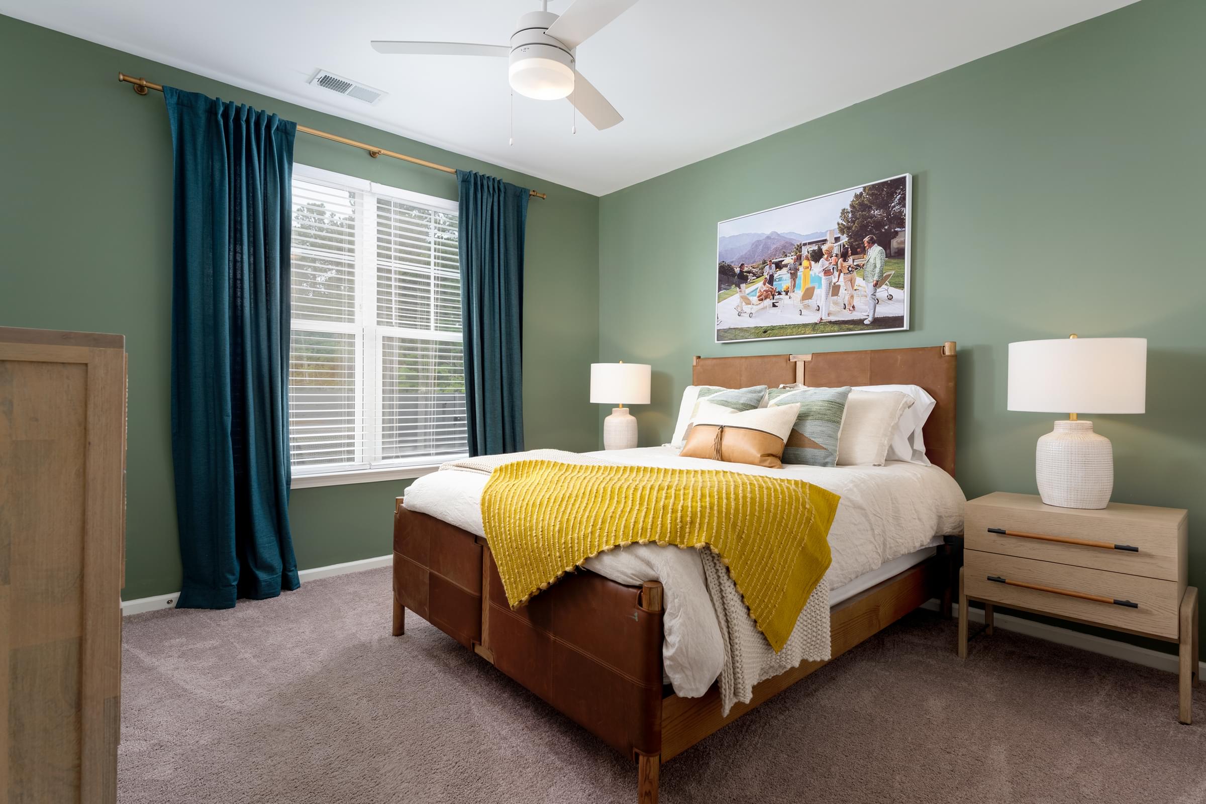 A bedroom with a bed, nightstand, and a painting on the wall at Hawthorne at Holly Ridge in NC