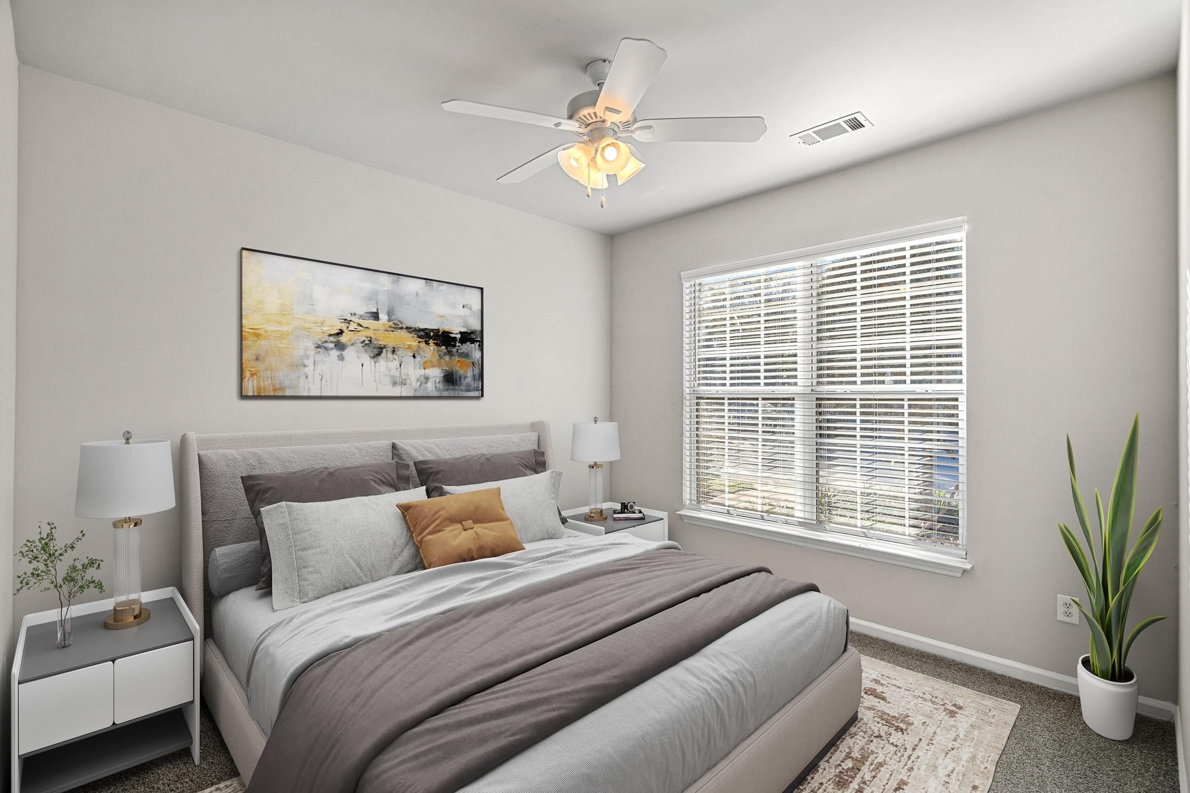 A bedroom with a large bed, a ceiling fan, and a painting on the wall at Hawthorne Bridford in Greensboro, NC.