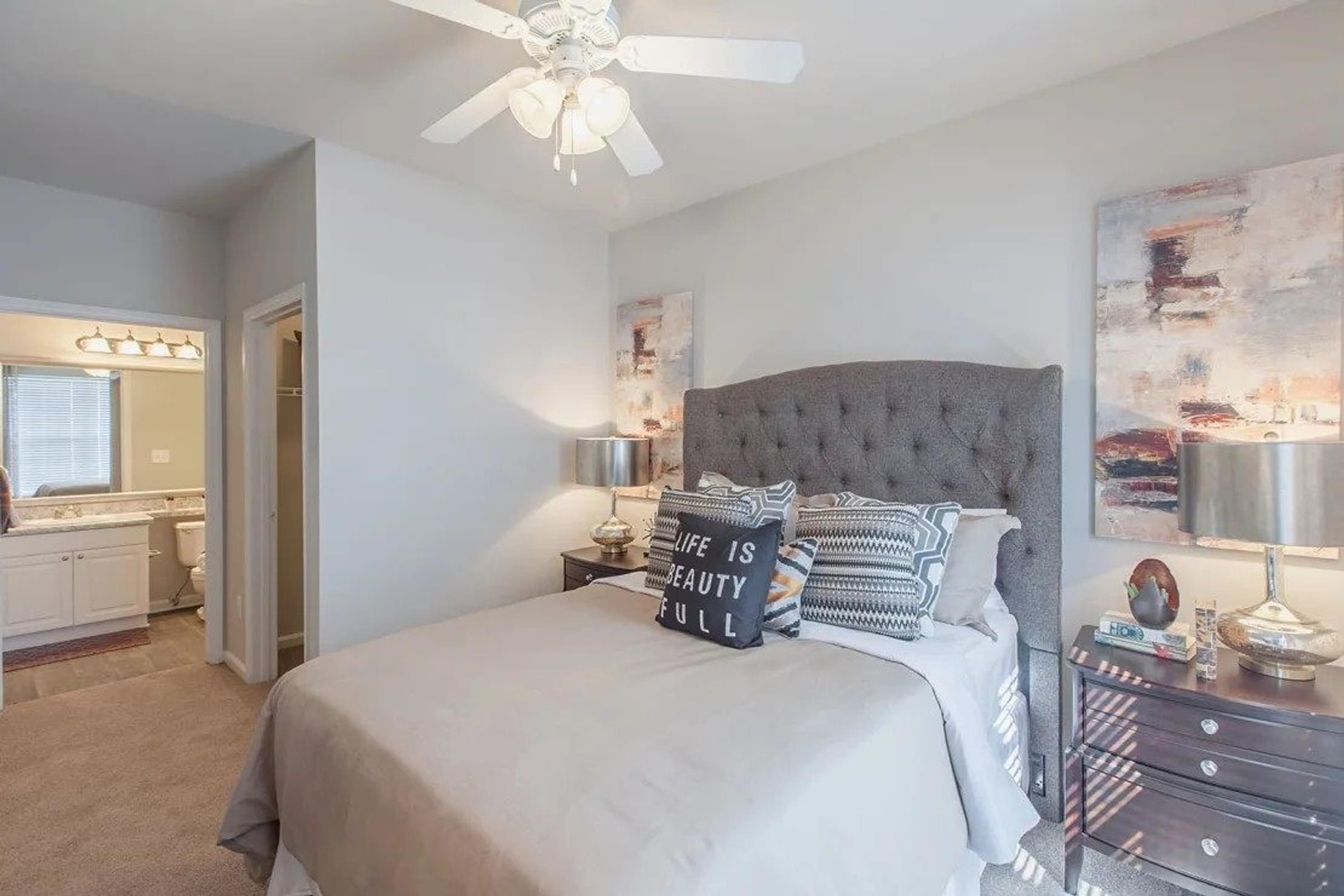A Bedroom with a Large Bed, a Dresser, and a Ceiling Fan.
