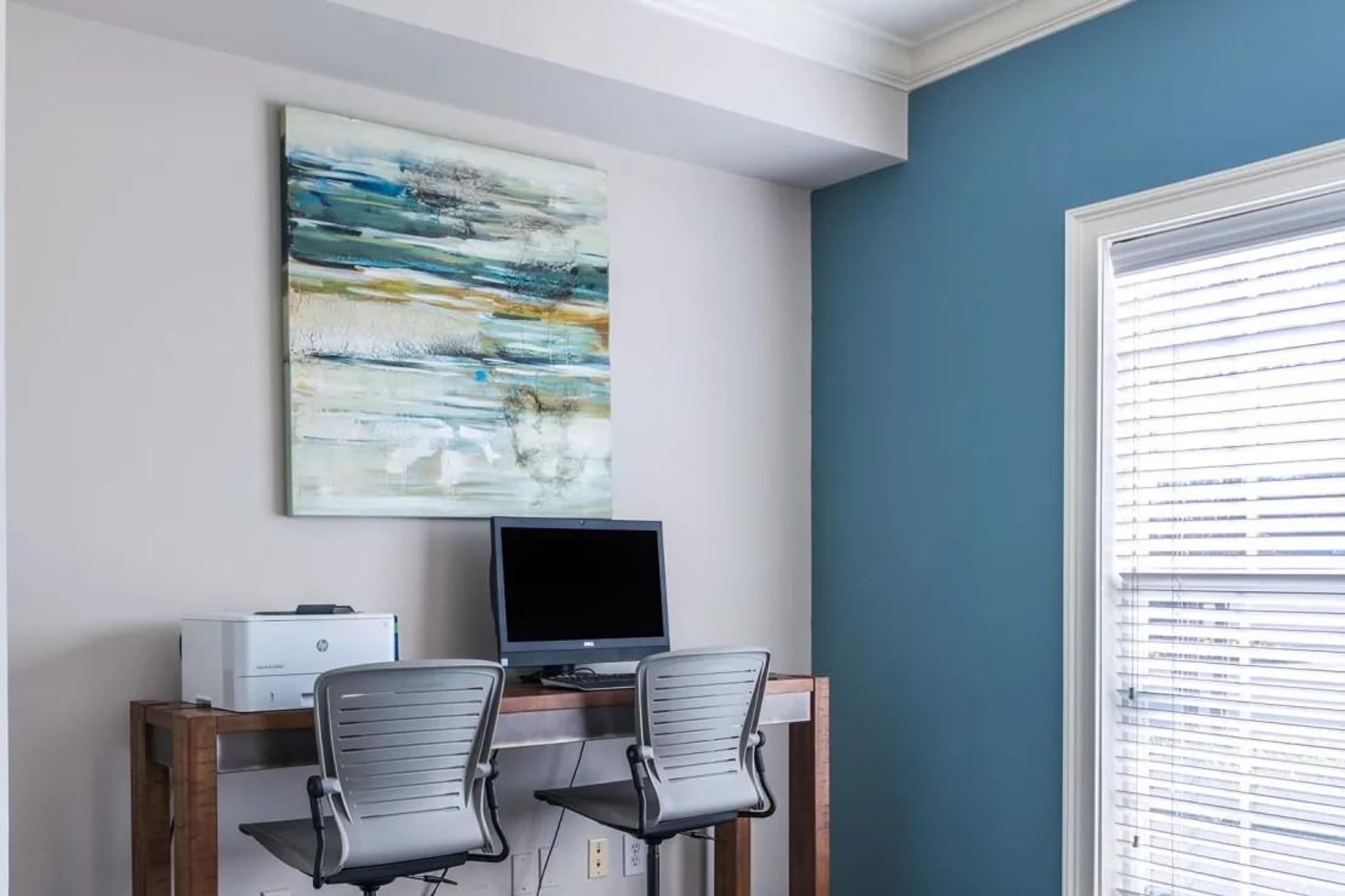 Desk with Two Chairs and a Computer in the Clubhouse.