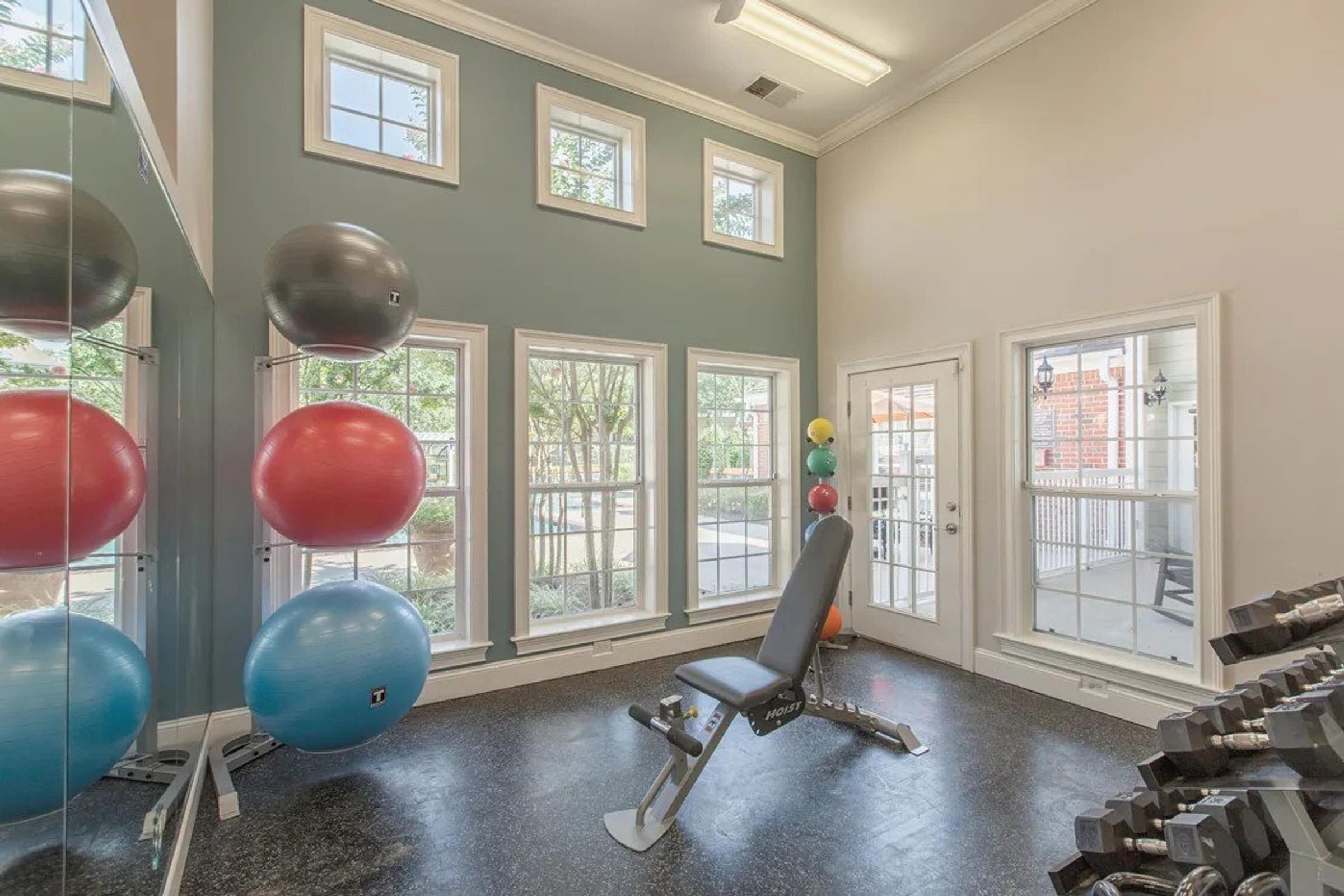Indoor Gym with a Weight Bench and Row of Windows to See Out.