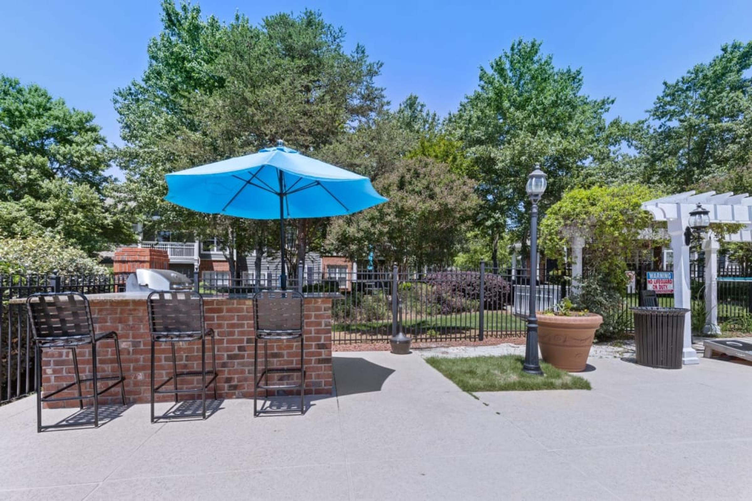 A Blue Umbrella is on a Patio Table with Chairs.