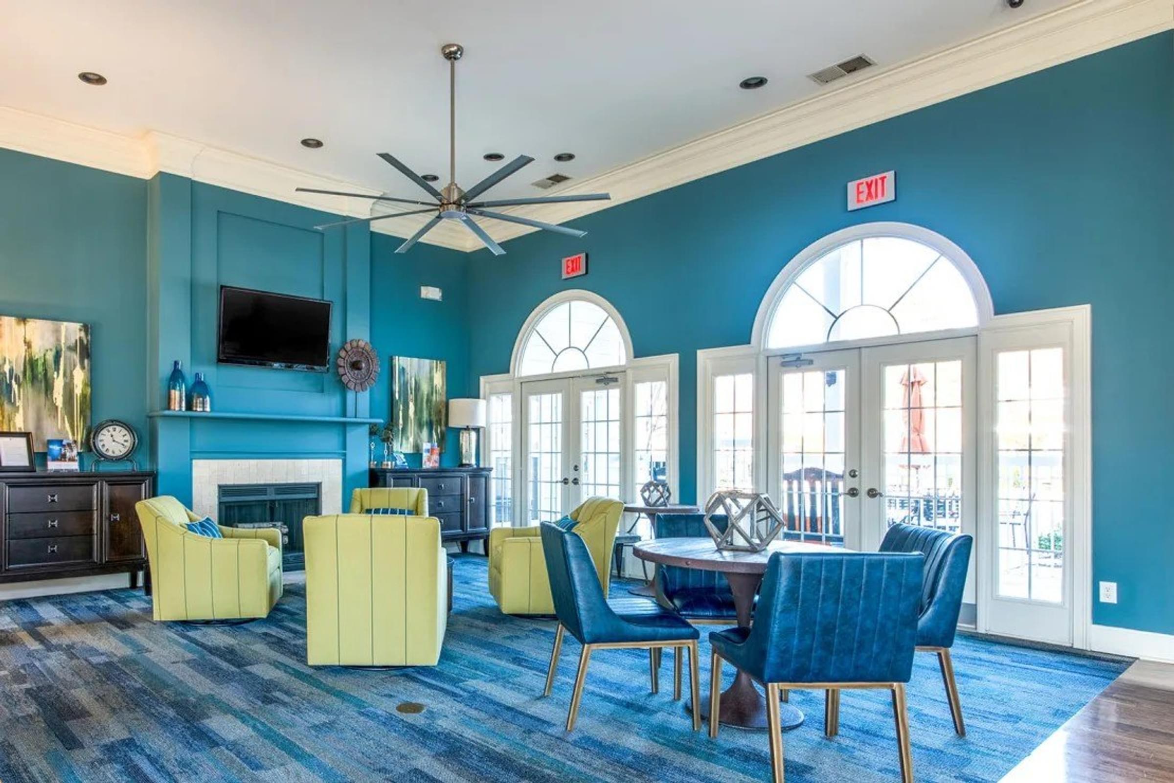 Clubhouse Living Area with a Fireplace, Chairs, and a Ceiling Fan.