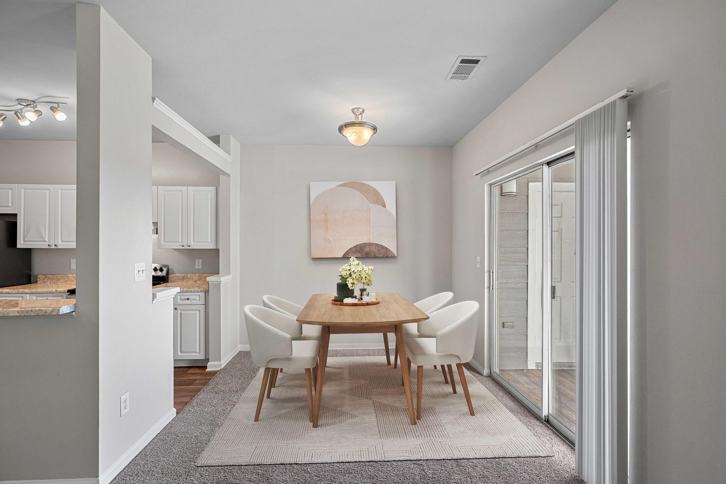 A dining room with a table set for four at Hawthorne Bridford in Greensboro, NC