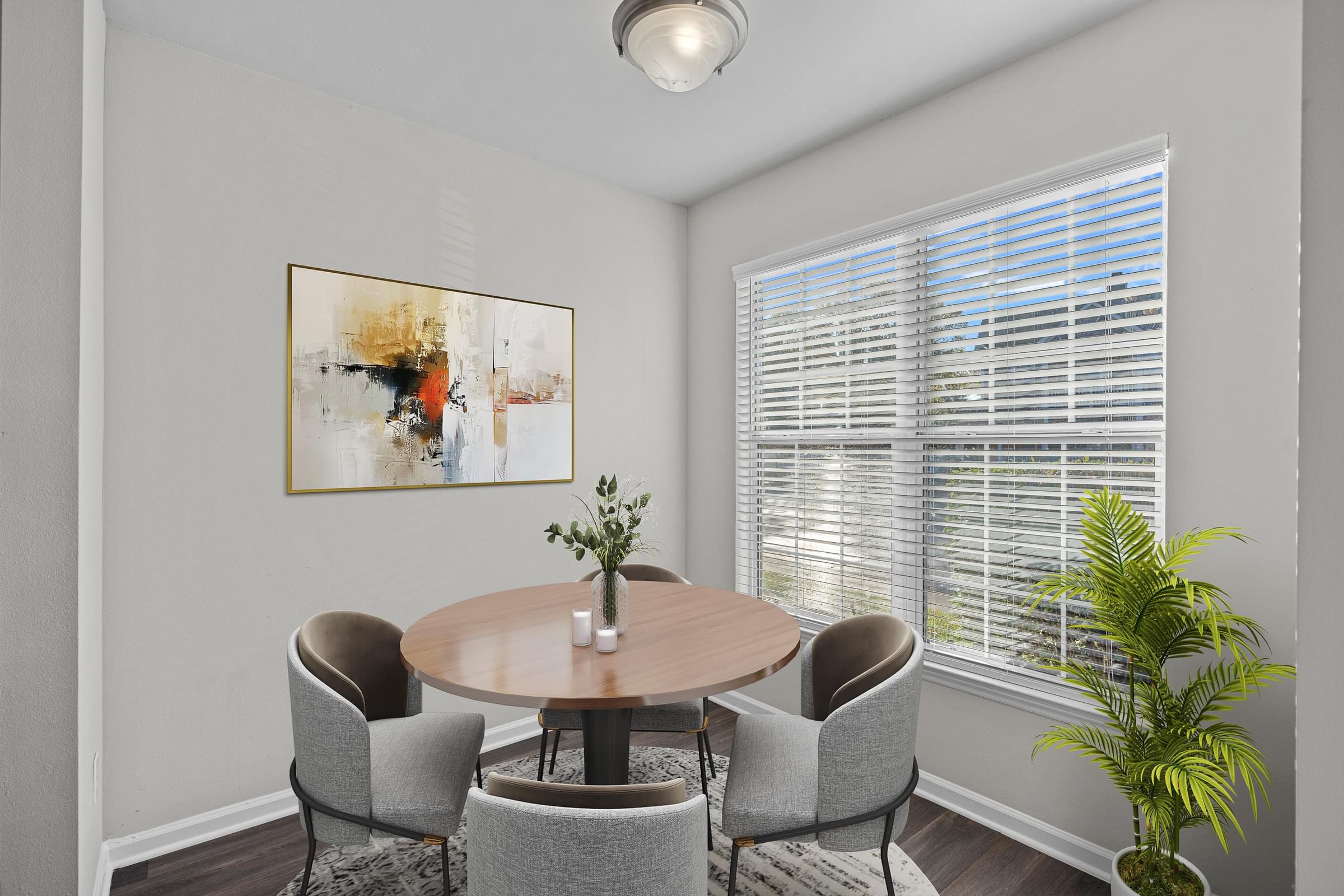 A dining room with a round table and chairs at Hawthorne Bridford in Greensboro, NC