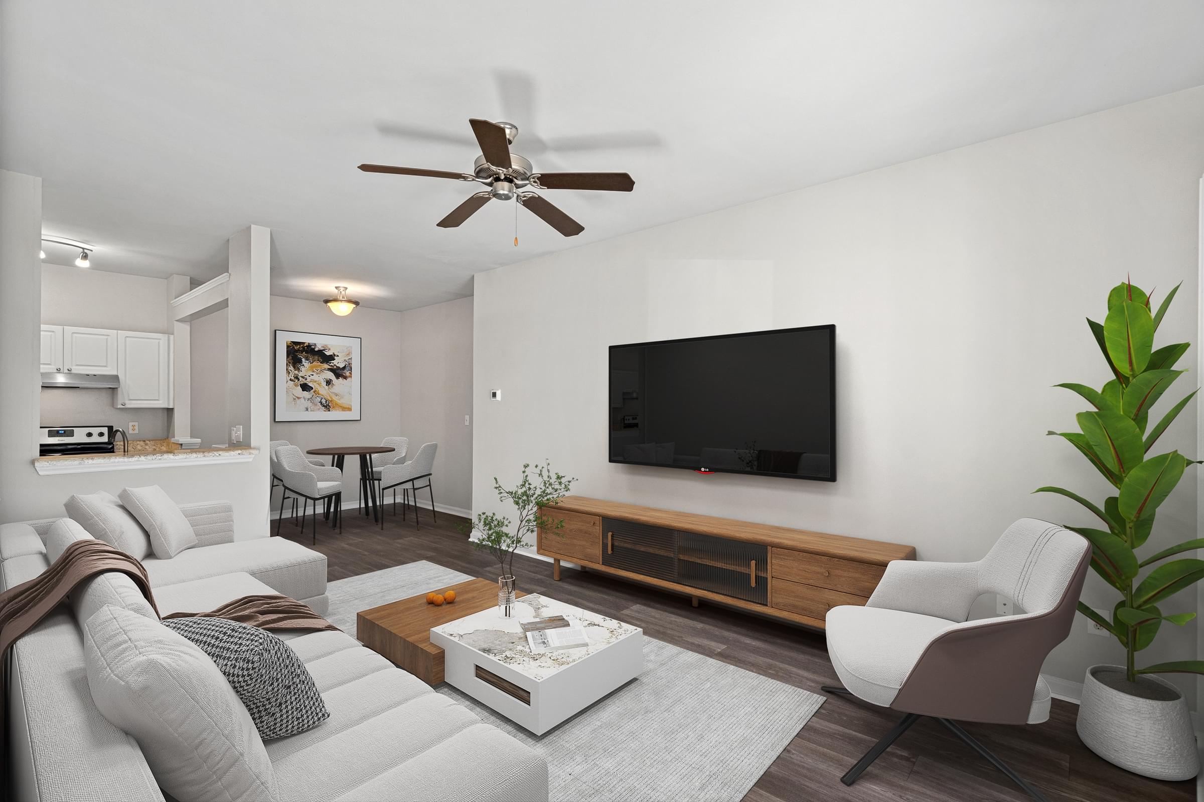 A modern living room with a white sofa, a wooden coffee table, and a flat-screen TV mounted on the wall at Hawthorne Bridford in Greensboro, NC