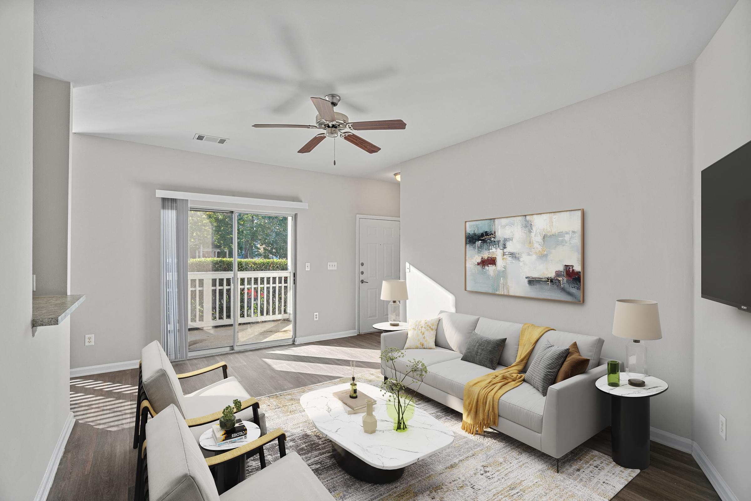 A living room with a grey couch and a painting on the wall at Hawthorne Bridford in Greensboro, NC