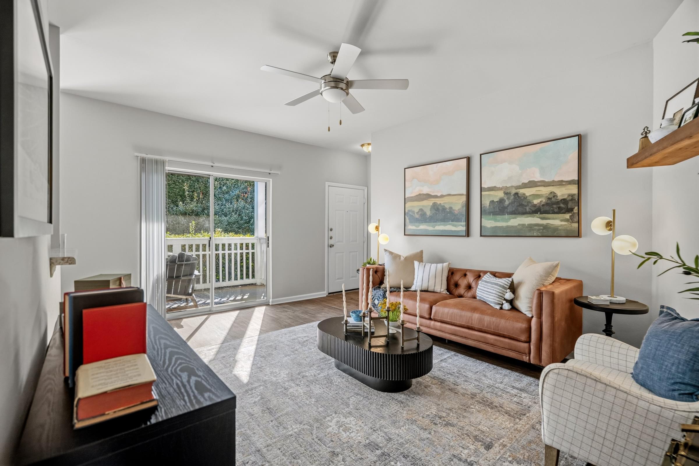 A living room with a brown couch, a coffee table, and a painting on the wall.
