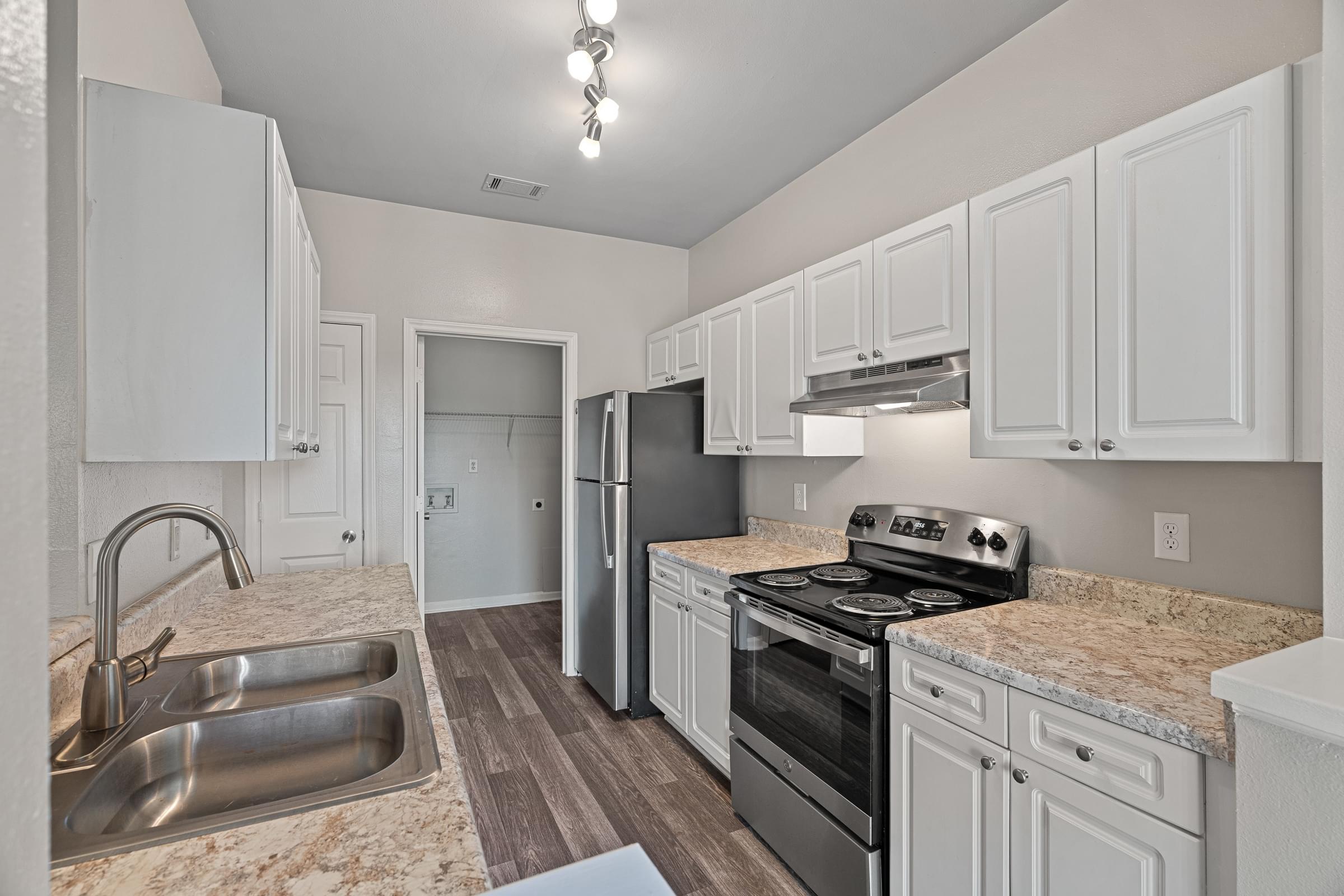 A kitchen with white cabinets and a granite countertop.