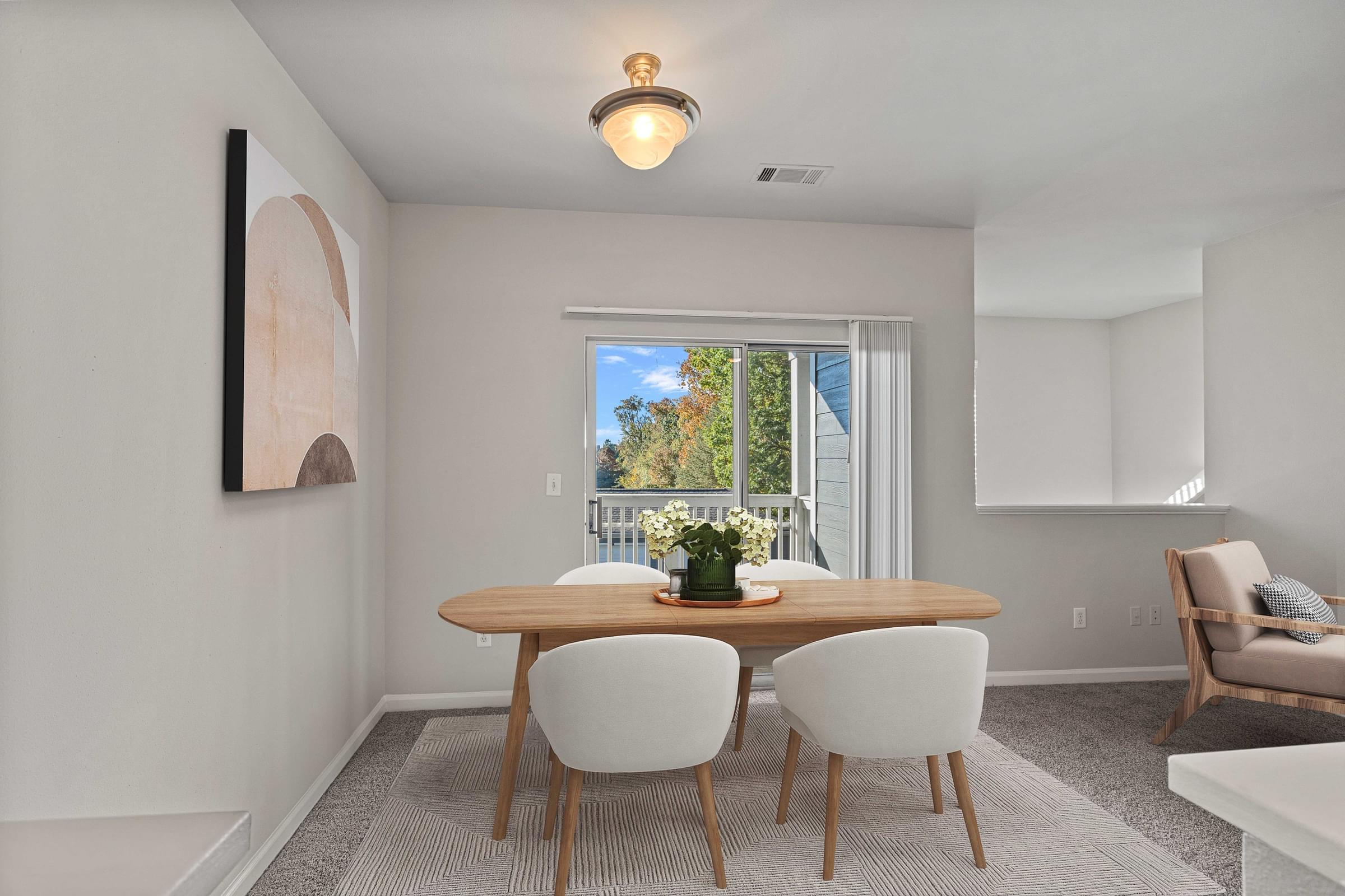 A dining room with a table and chairs.
