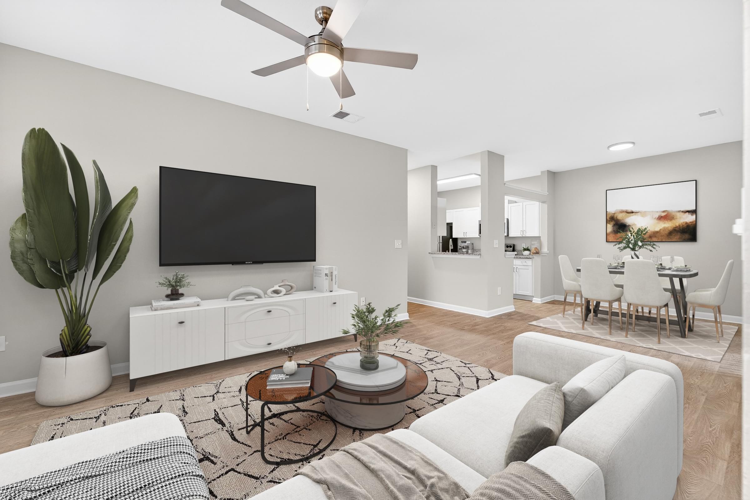 A living room with a white couch, a coffee table, and a television.
