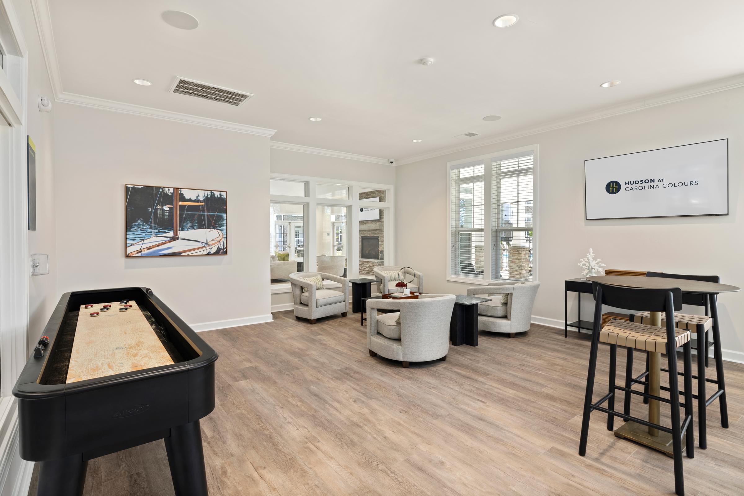A Gameroom with Seating and Billiard Table in the Middle of the Room.