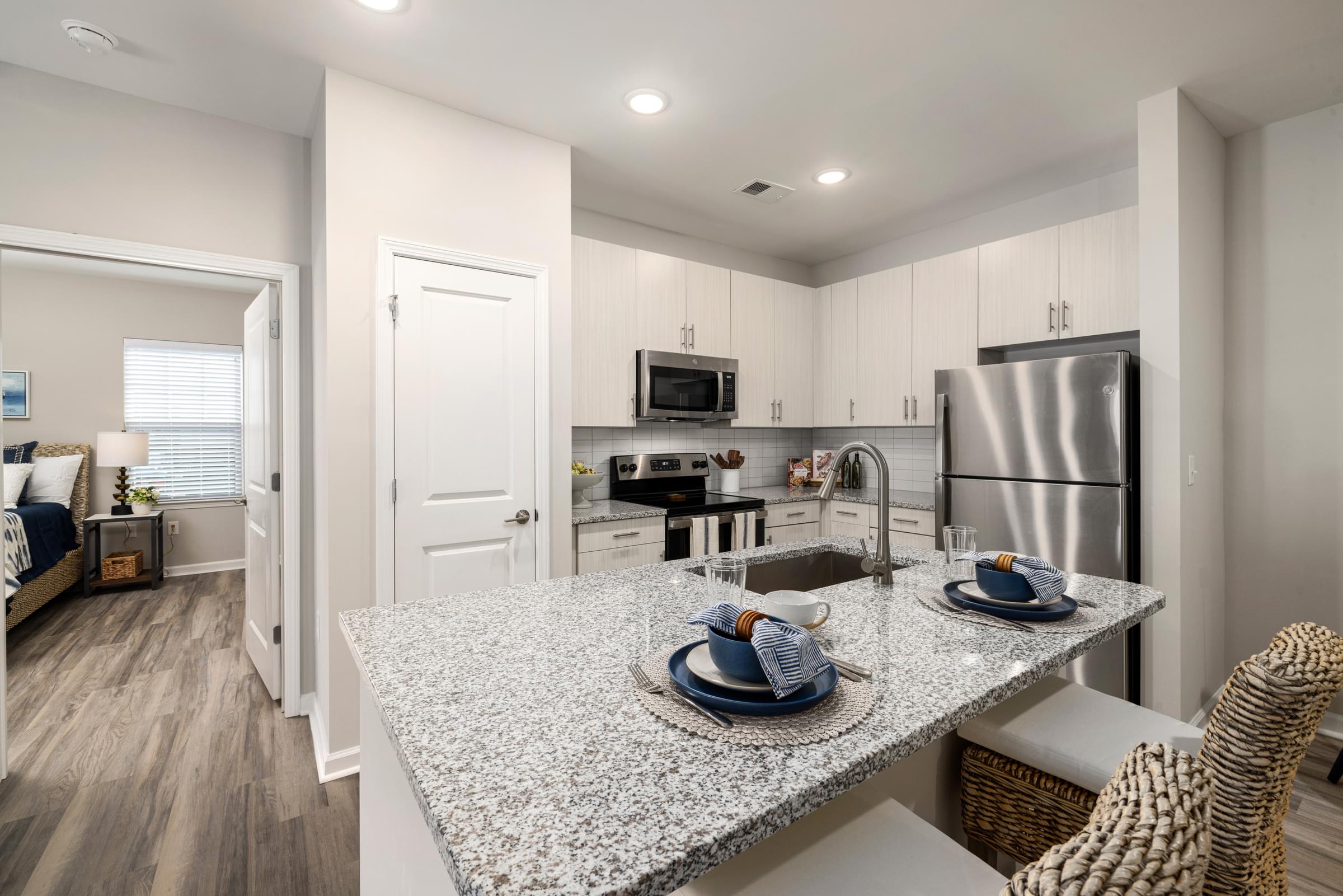 Interior Unit Kitchen with Granite Countertop, Refrigerator and Microwave.