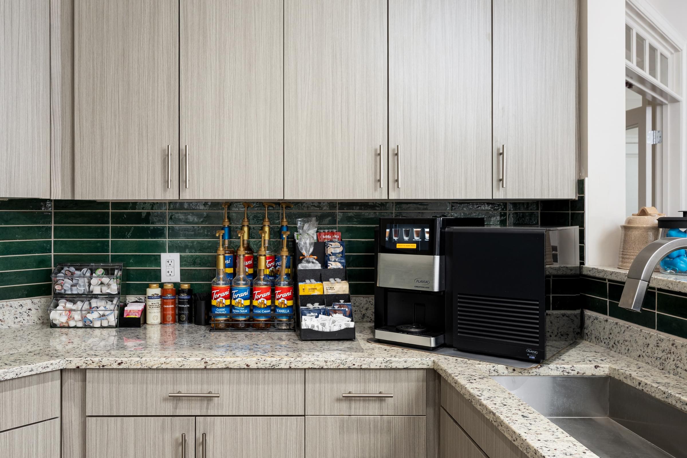 A kitchen with a black microwave oven and a countertop with various food items.