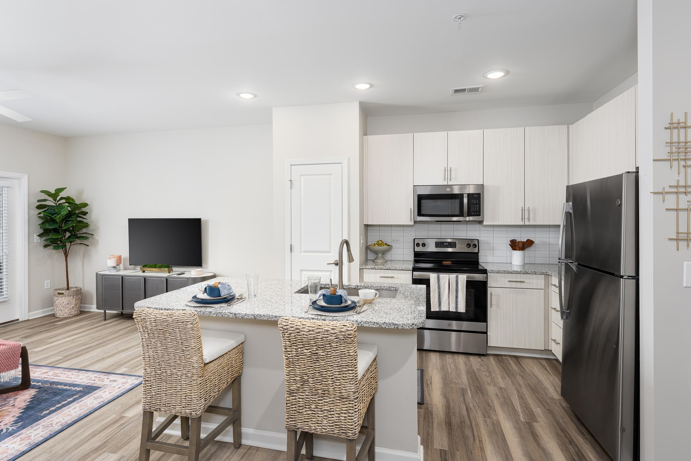 A kitchen with a refrigerator, microwave, and oven.