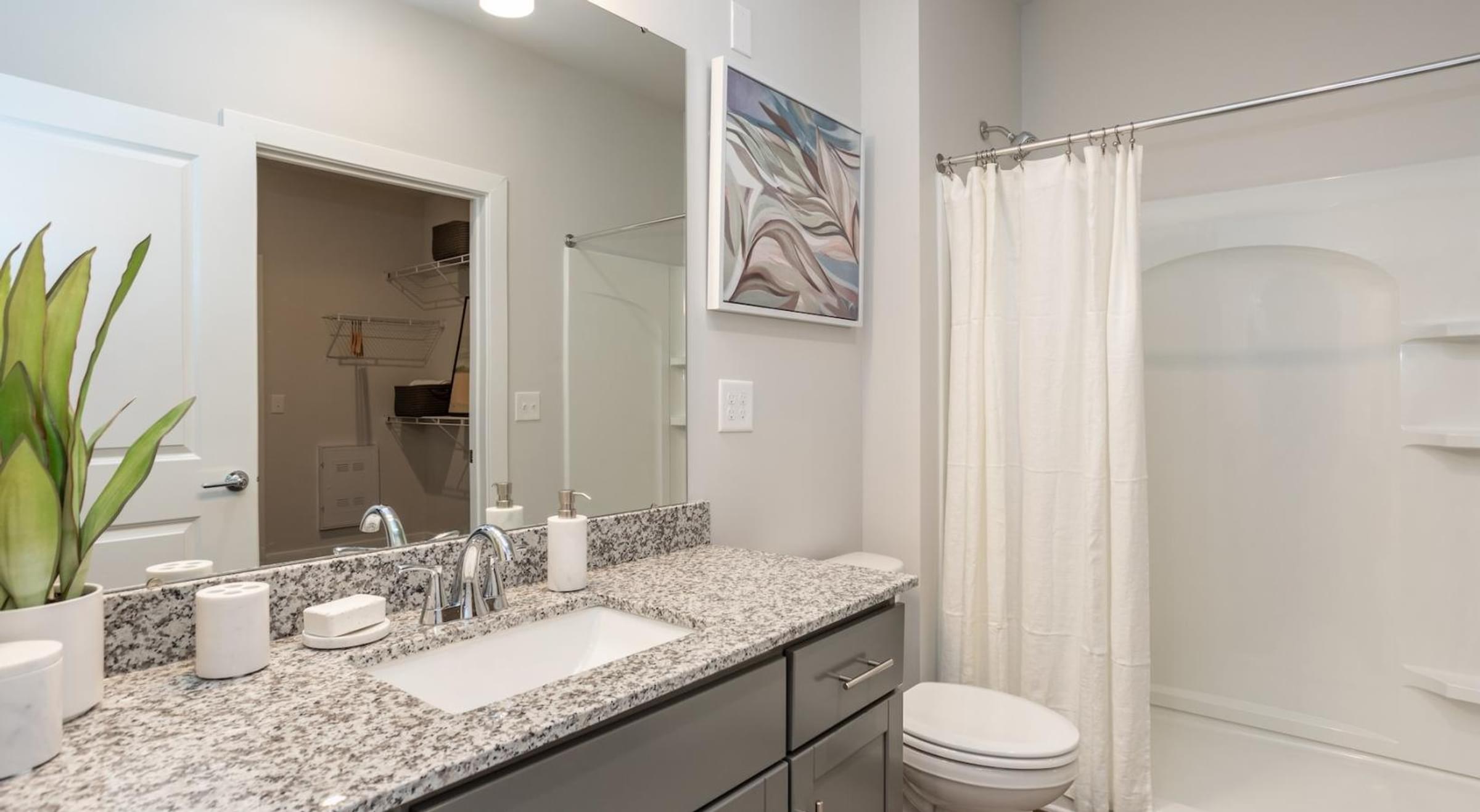 Bathroom with a sink, toilet, and a painting hanging on the wall.